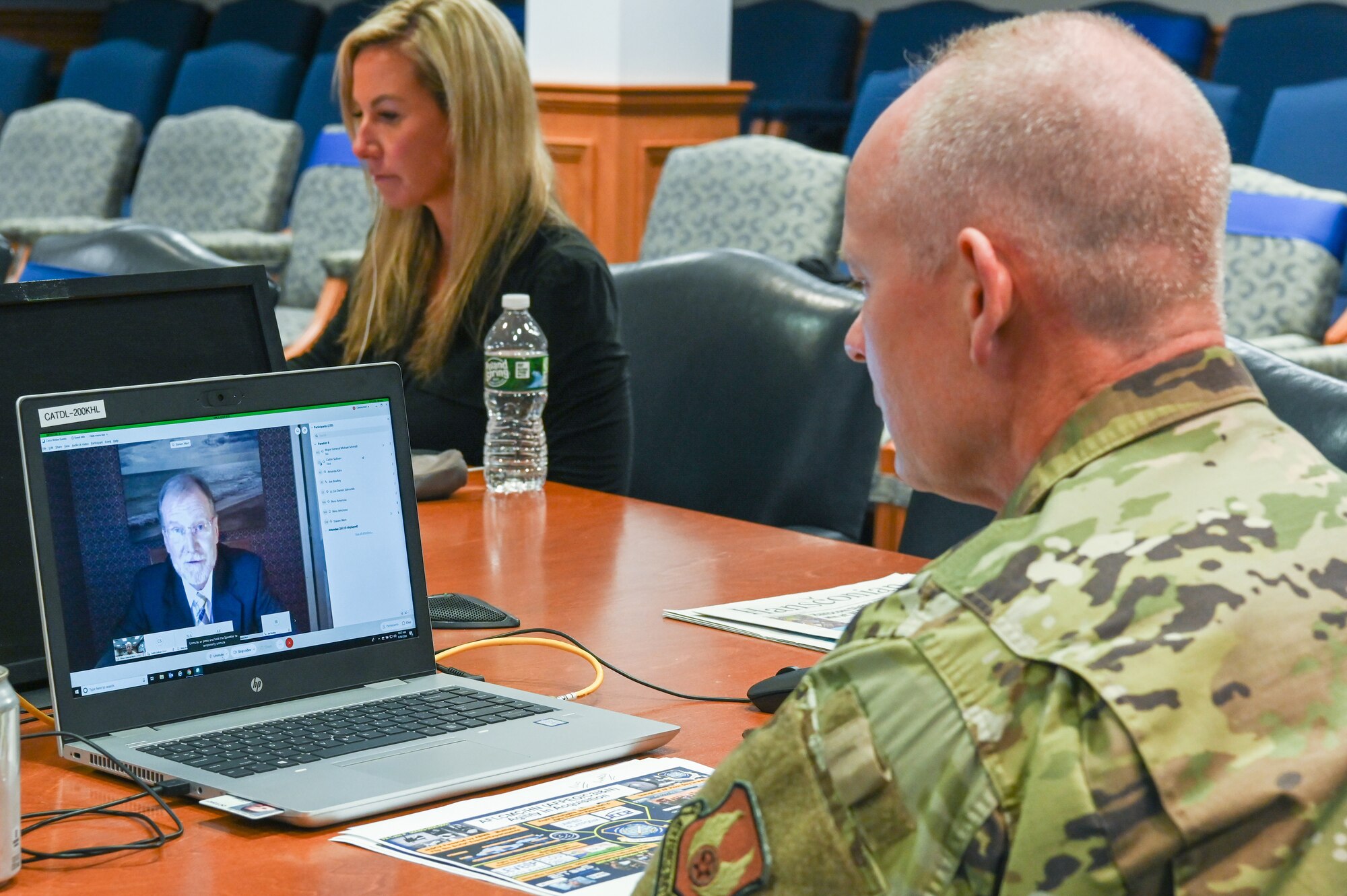 Maj. Gen. Michael Schmidt, right, program executive officer for Command, Control, Communications, Intelligence and Networks, speaks to Steve Wert, PEO for Digital, and other Hanscom Collaboration and Innovation Center symposium participants via Webex, while Caitlin Sullivan, with Gartner Air Force Programs, looks on, Sept. 30.