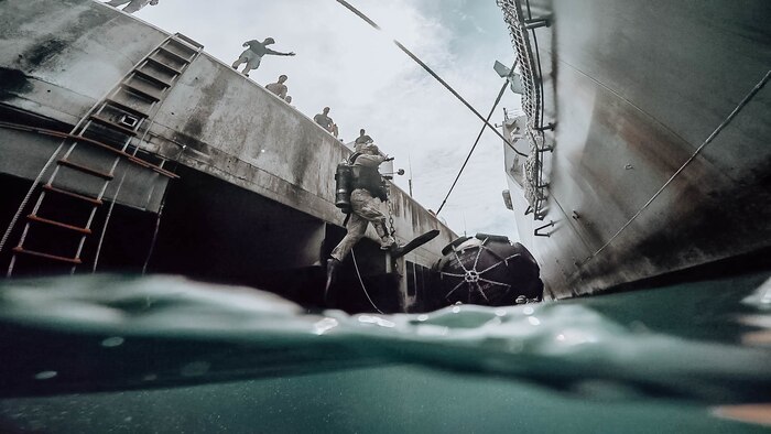A U.S. sailor jumps off a pier during an inspection dive at White Beach, Okinawa, Japan, Sept. 28.
