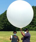 IMAGE: DAHLGREN, Va. - Naval Surface Warfare Center Dahlgren Division (NSWCDD) scientists Kayla Frye and Dr. Chris Brown prepare a weather balloon sounding for tests in support of a collaborative research project combining the Navy’s next-generation laser weapons with maritime environmental challenges. Frye and Brown conducted the tests to measure for optical turbulence. Dr. Evan Bates - an NSWCDD systems engineer who leads the High Energy Laser Measurement Support Laboratory - hopes to take the instruments used for optical turbulence measurements and incorporate them into shipboard lasers in the future. “You want to be able to get a real-time measurement with a single-ended system, because if we can get that we can look at the environment and evaluate the atmospheric effects on laser transmission to the target," said Bates. "That’s the end goal of optical turbulence instrumentation.” (U.S. Navy photo/Released)