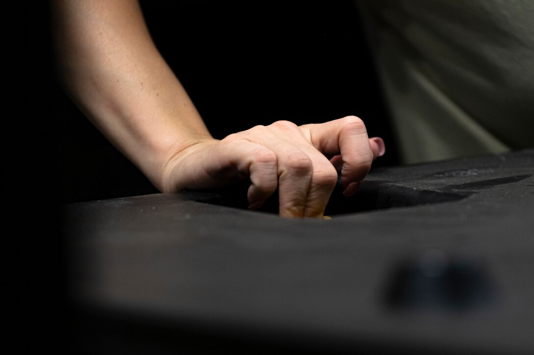 A photo of an Airman securing a lid on a box
