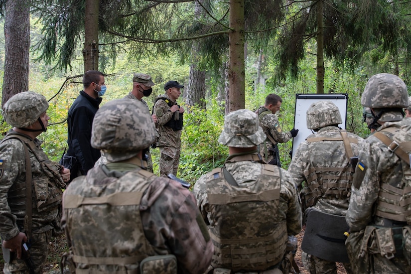 A group of soldiers meet in the forest.