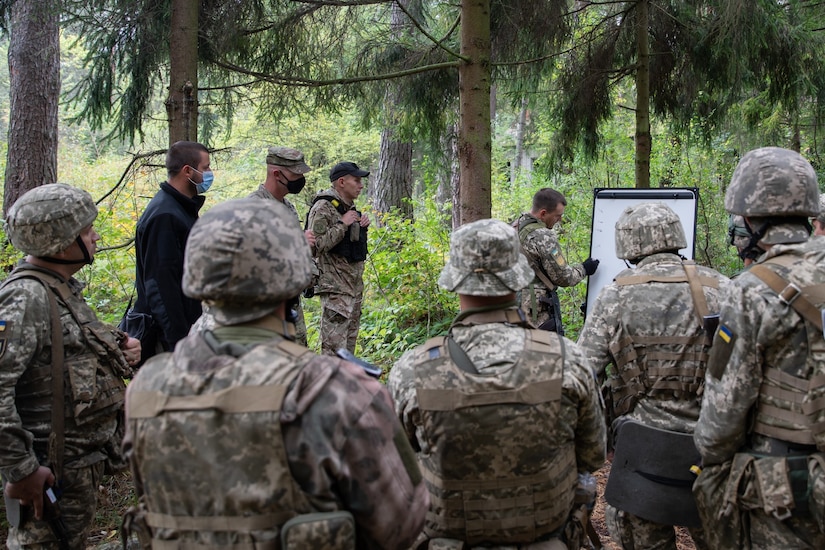 A U.S. military officer stands in formation alongside fellow service members.