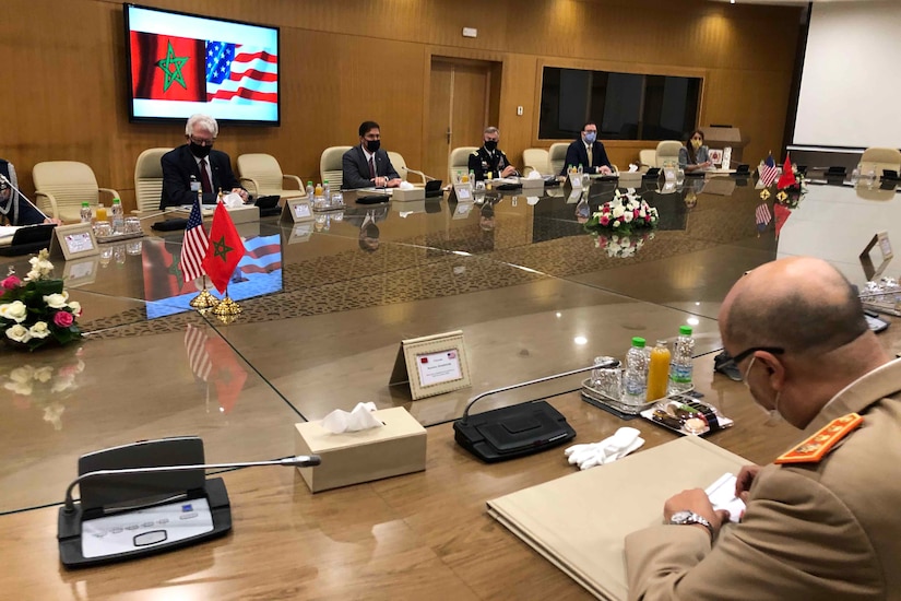 Men sit at a very large conference table.