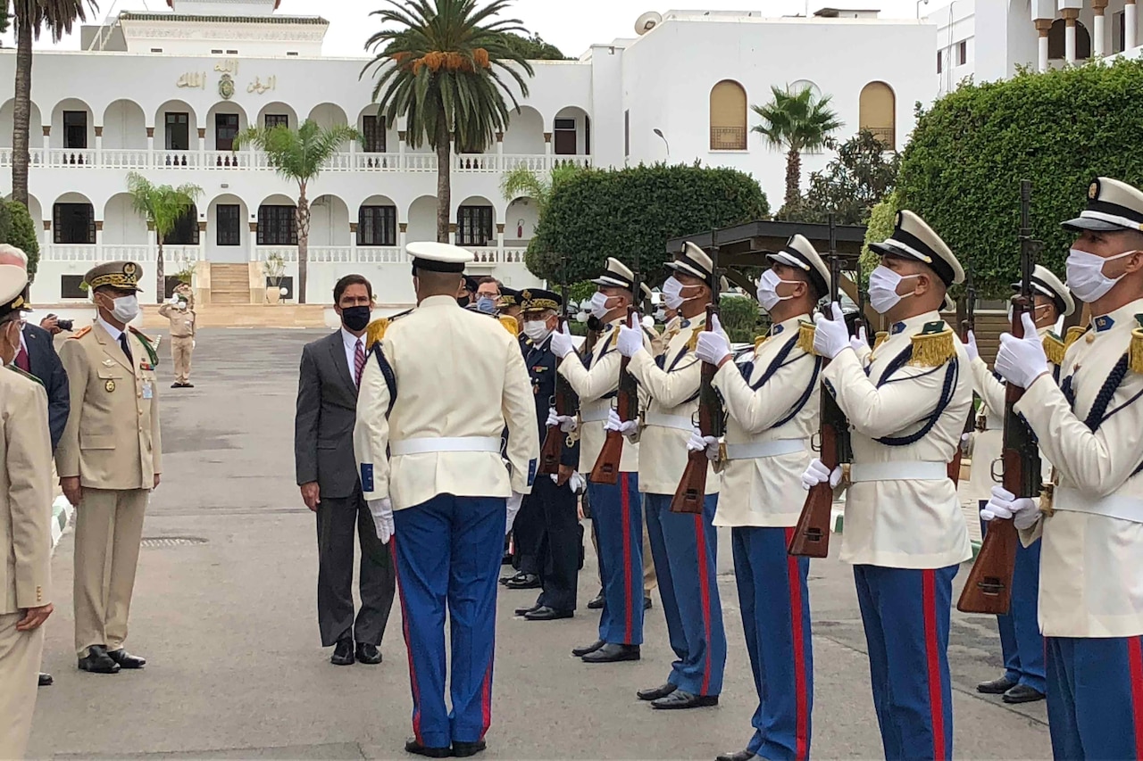 Soldier salutes man in business suit.