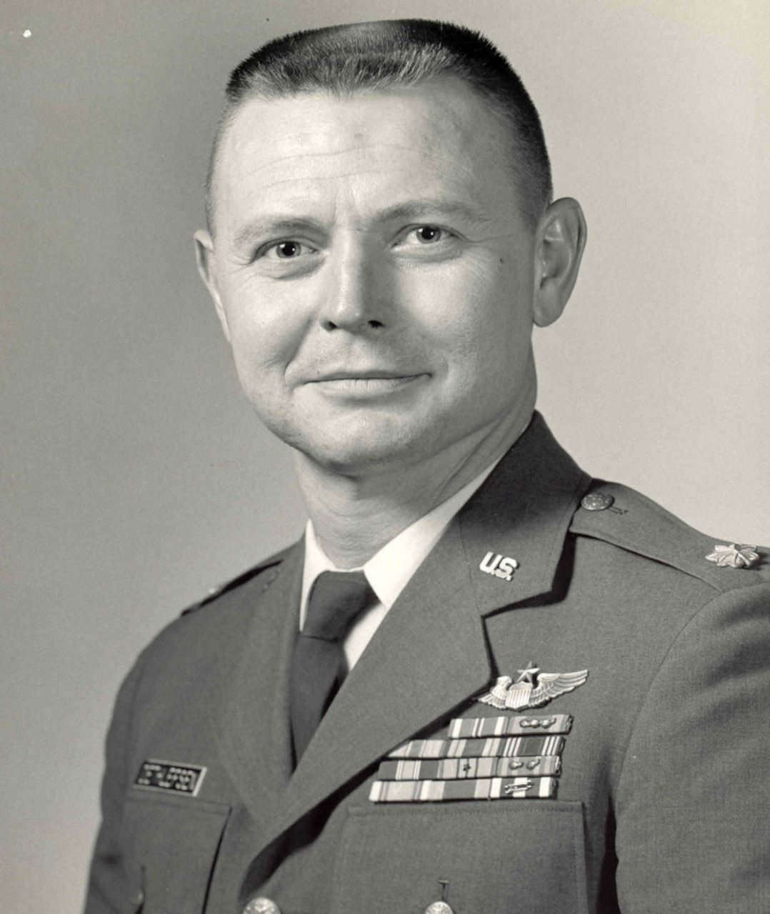 A man in uniform looks toward a camera.