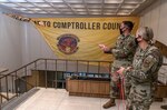 Brig. Gen. Caroline Miller, 502d Air Base Wing and Joint Base San Antonio commander, right, visited the Dragons on Sept. 30 to congratulate the budget analysis team and to unfurl the unit banner—symbolically celebrating the 502nd Comptroller Squadron consolidation efforts at JBSA-Lackland and the reopening of customer lobbies at all JBSA locations.