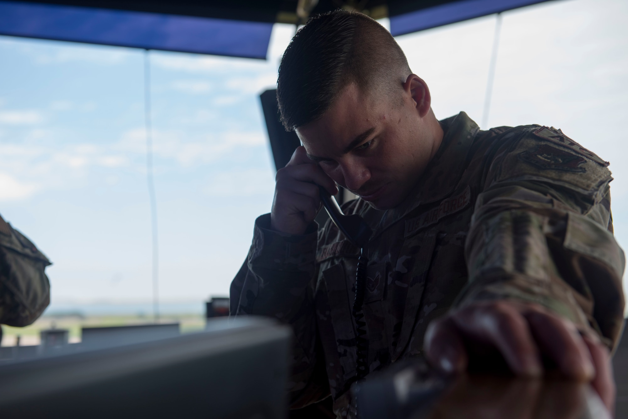 A photo of an Airman answering a phone call