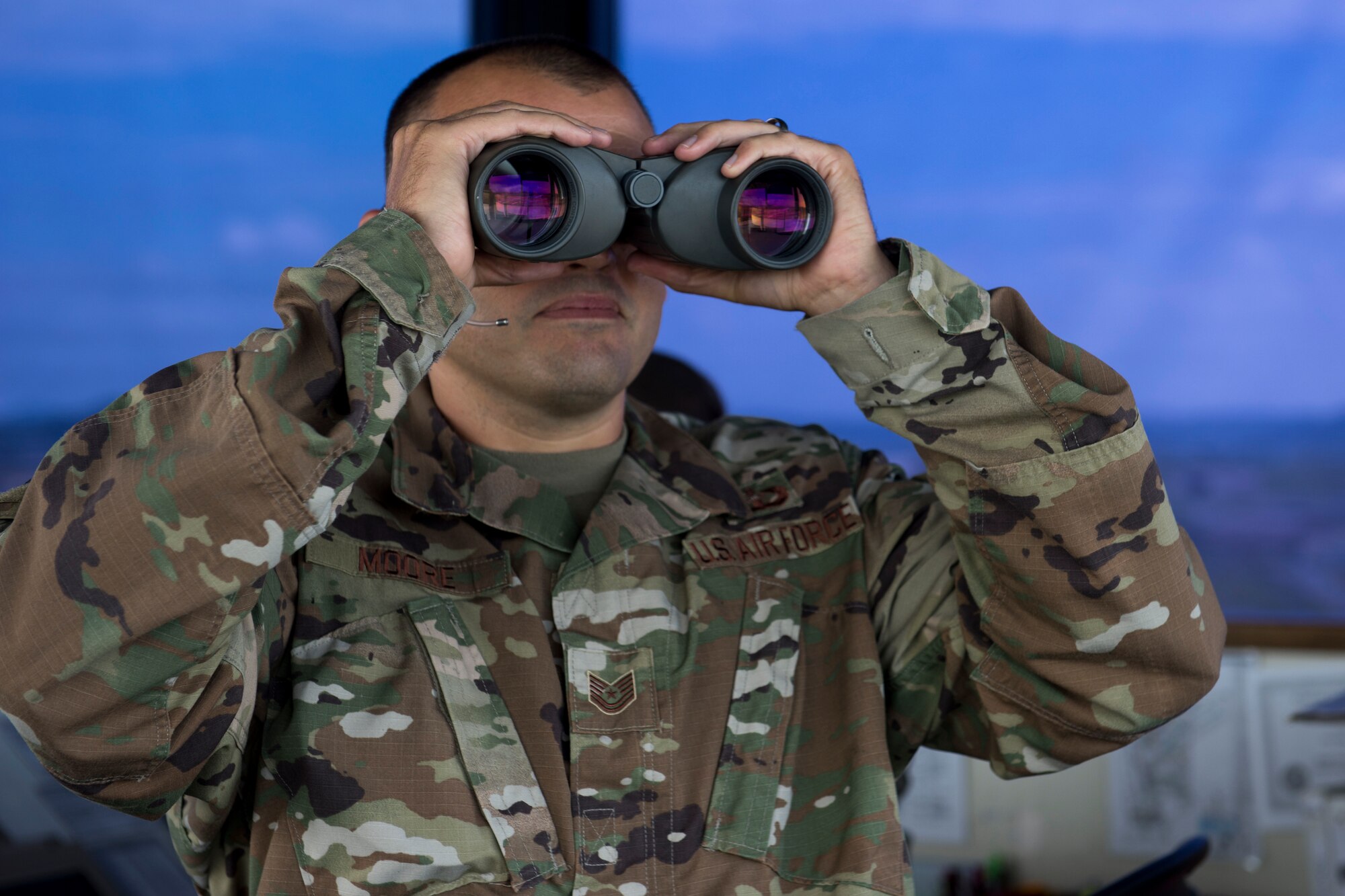 A photo of an Airman looking through binoculars
