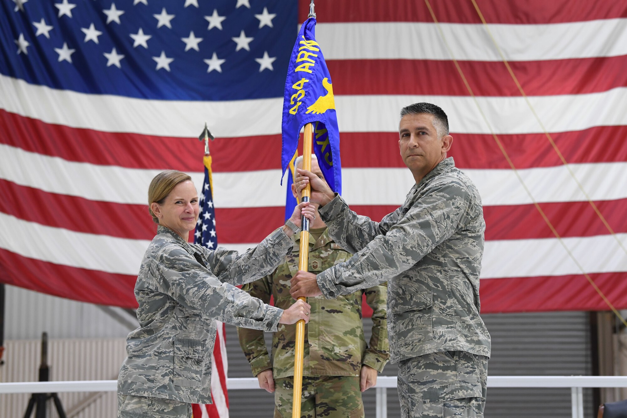 Lt. Col. John Valdes, former 434th Aircraft Maintenance Squadron commander, symbolically presents a guidon to Col. Arianne Mayberry, 434th Maintenance Group commander, during a change of command ceremony at Grissom Air Reserve Base, Oct. 4, 2020. Valdes held the position for the past 5 years. (U.S. Air Force photo / A1C Harrison Withrow)