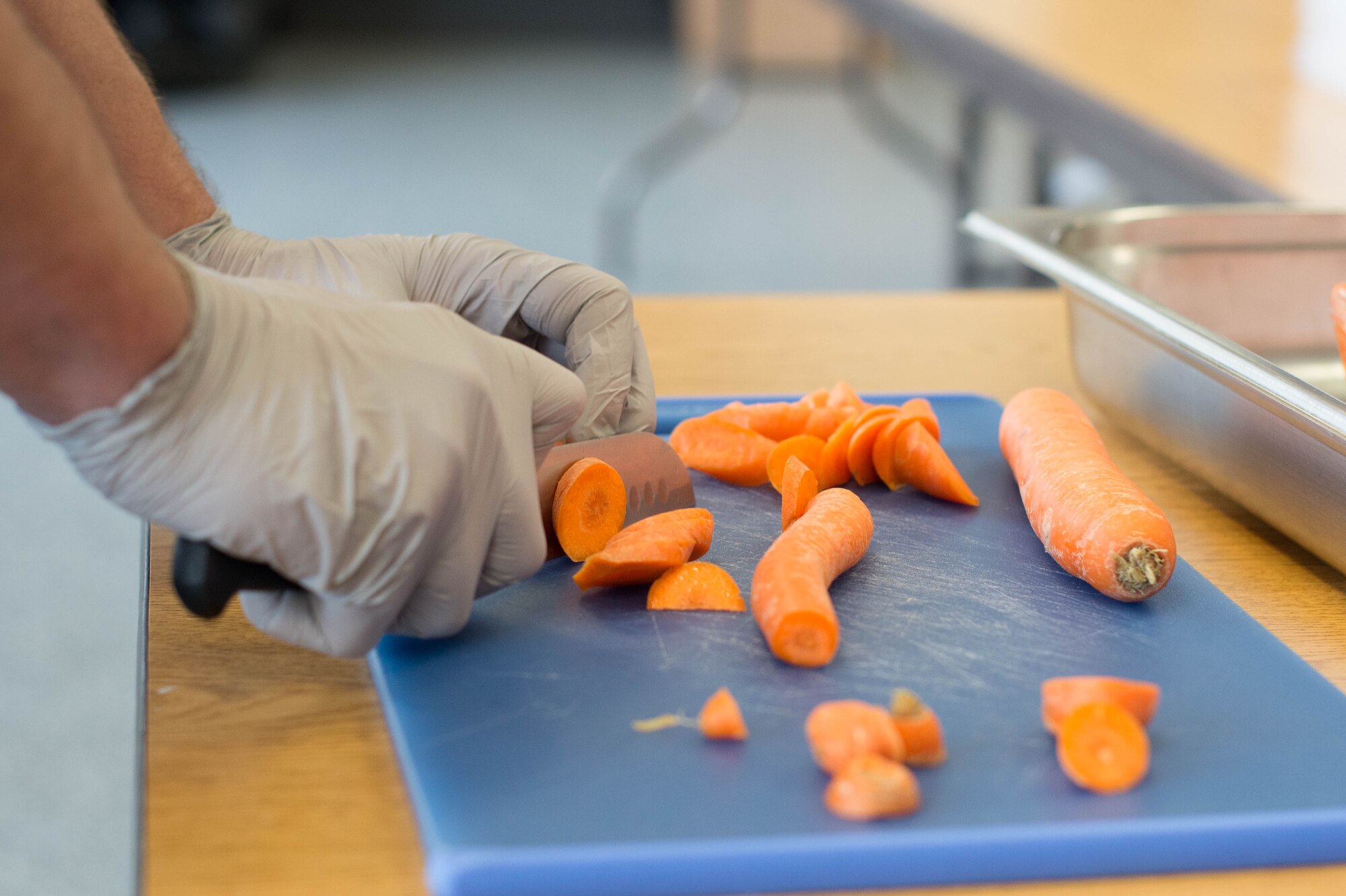 Photo of hands chopping carrots.
