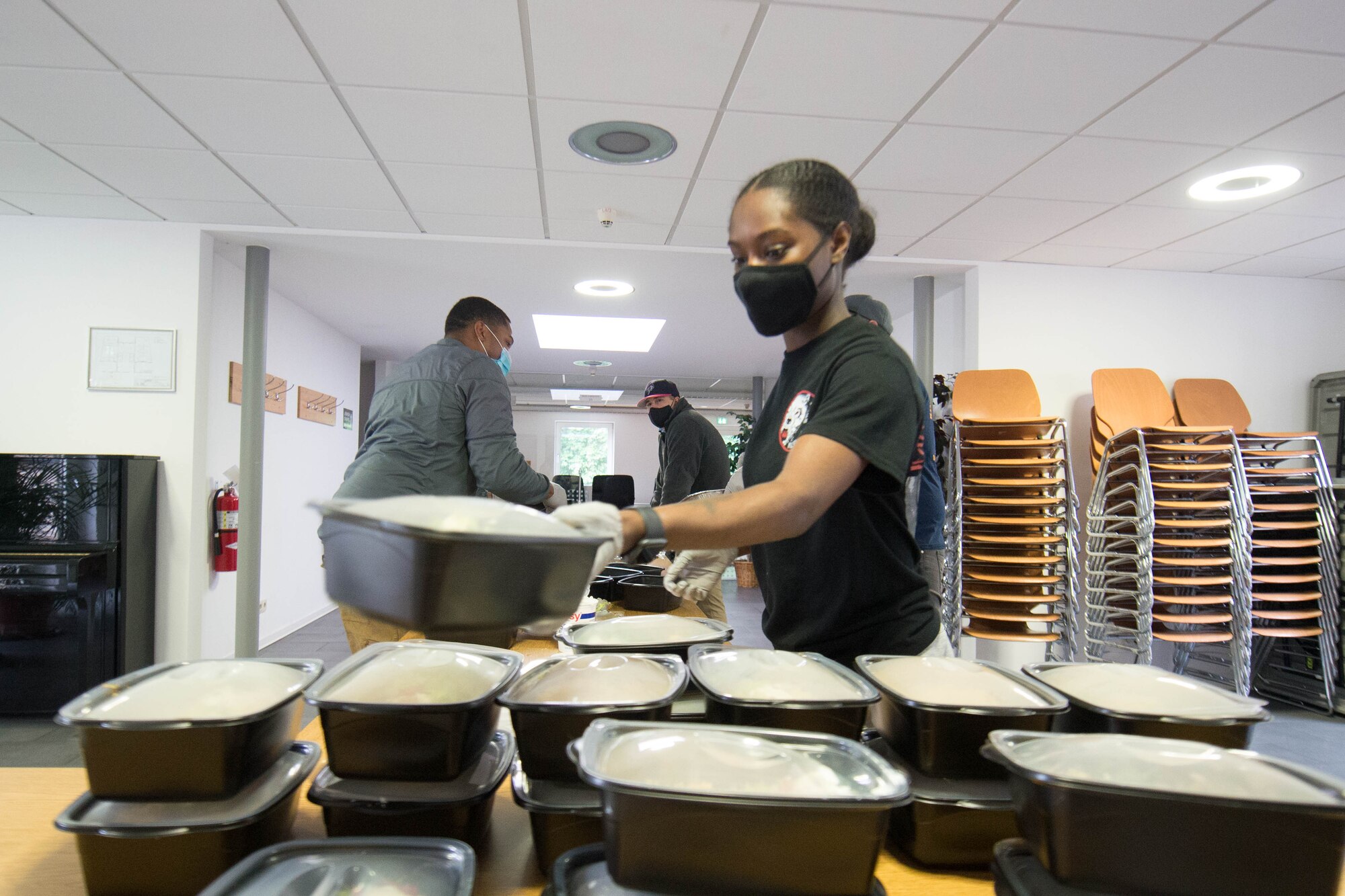 Photograph of a volunteer stacking meals that are ready for delivery.