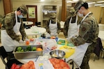 From left to right, Alaska Air National Guard Tech Sgt. Brayden Van Bevera, Airman 1st Class Fionna Kelty, Tech Sgt. Allen Wilson and Senior Airman Alex Choi, all members of the 176th Force Support Flight Sustainment Services, cut fresh produce at the Five Loaves, Two Fish Kitchen in Wasilla, Alaska, Sept. 25, 2020. The Airmen have been volunteering at the kitchen since mid-August, preparing an average of 150 meals per week for non-profit organizations.