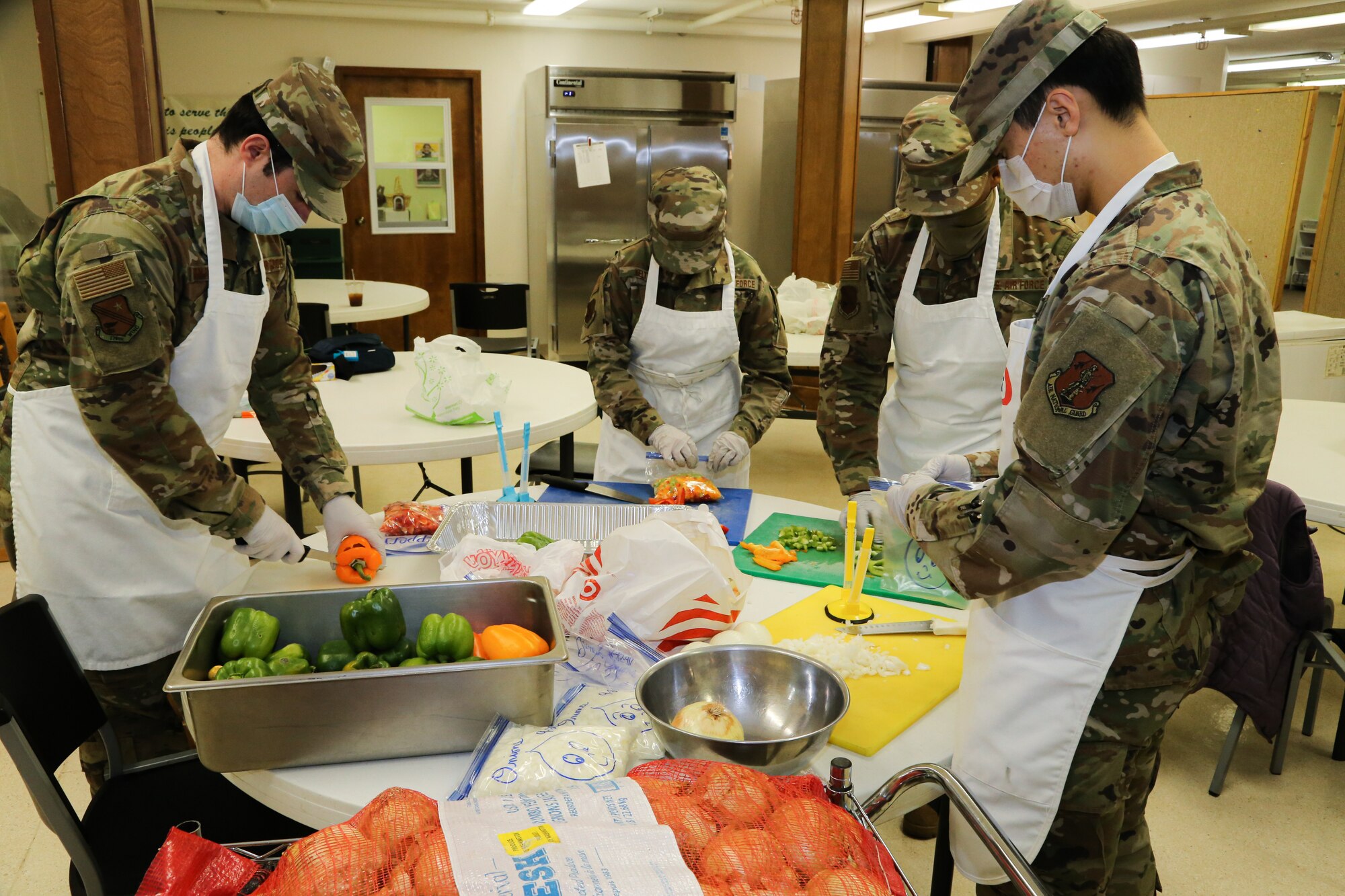 From left to right, Alaska Air National Guard Tech Sgt. Brayden Van Bevera, Airman 1st Class Fionna Kelty, Tech Sgt. Allen Wilson and Senior Airman Alex Choi, all members of the 176th Force Support Flight Sustainment Services, cut fresh produce at the Five Loaves, Two Fish Kitchen in Wasilla, Alaska, Sept. 25, 2020. The Airmen have been volunteering at the kitchen since mid-August, preparing an average of 150 meals per week for non-profit organizations.
