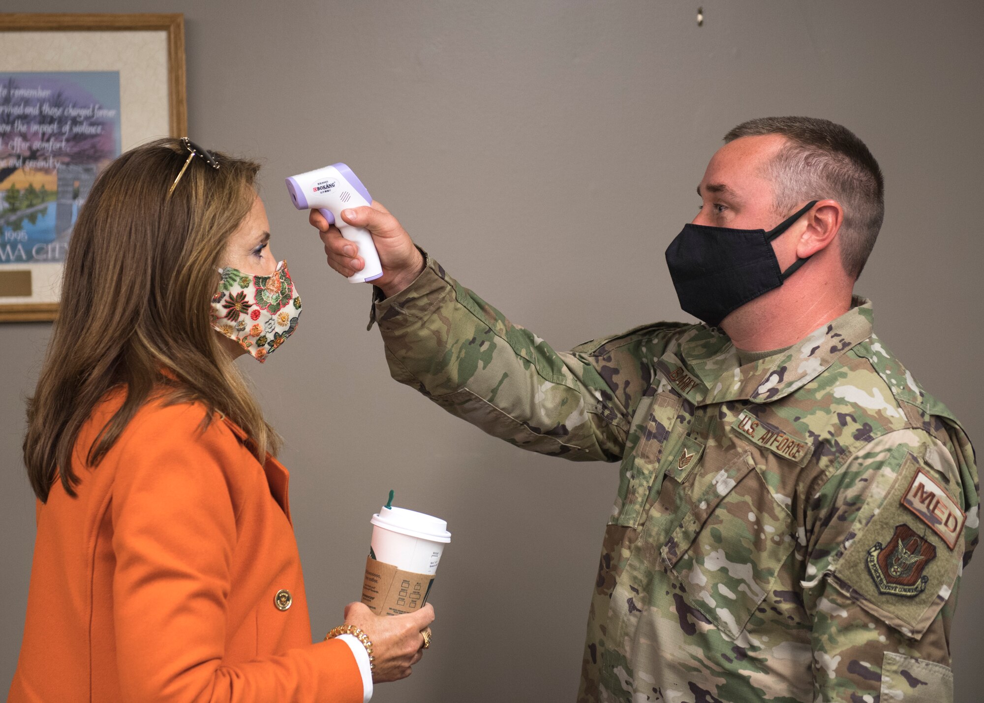 Tech. Sgt. Stephen Barey, medical technician with the 911th Aeromedical Staging Squadron, takes the temperature of Rochelle Stachel, president of HRV Conformance Verification Associates Inc., at the Pittsburgh International Airport Air Reserve Station, Pennsylvania, Oct. 1, 2020.