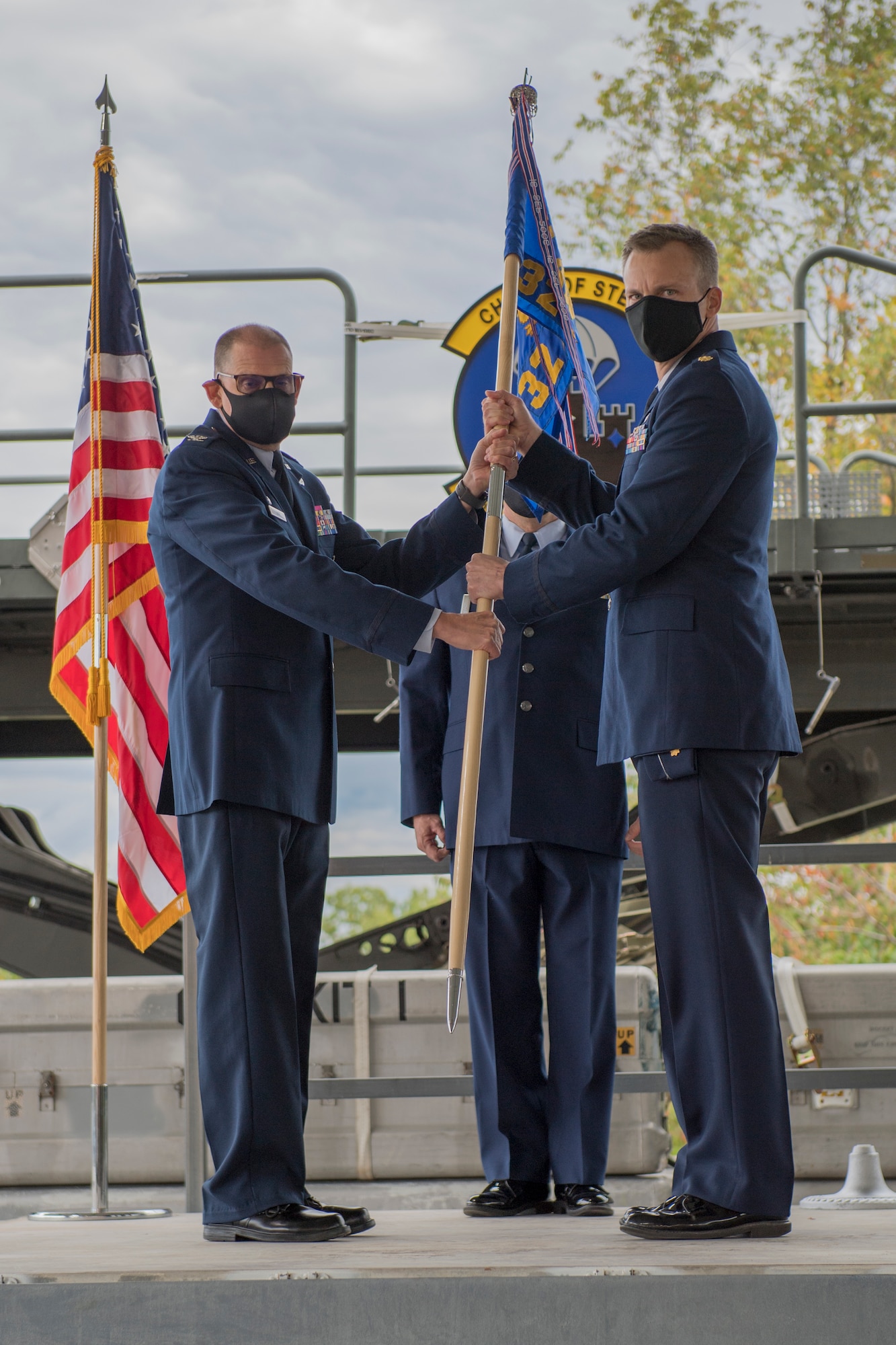 Col. Kenneth M. Lute, commander of the 911th Mission Support Group, passes the guidon during an assumption of command ceremony to Maj. Erik Hofmeyer, commander of the 32nd Aerial Port Squadron, at the Pittsburgh International Airport Air Reserve Station, Pennsylvania, Oct. 3. 2020.