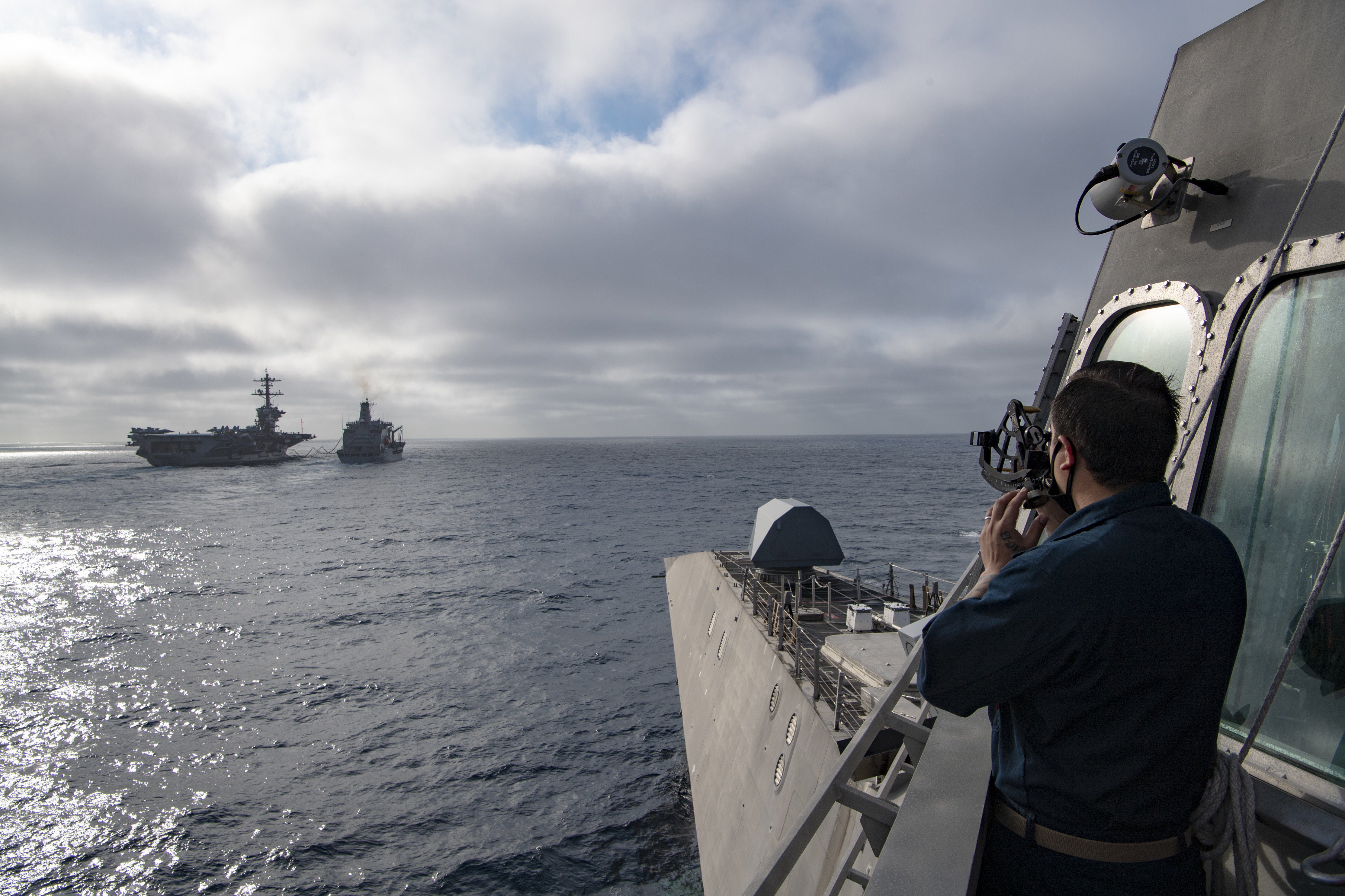USS Gabrielle Giffords (LCS 10) approaches USNS Guadalupe (T-AO 200), left foreground, and USS Theodore Roosevelt (CVN 71) during a replenishment-at-sea.