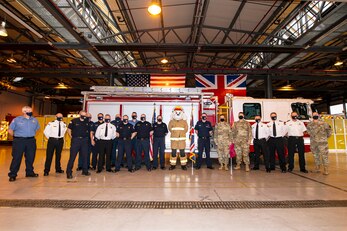 Firefighters and Airmen from the 423rd Air Base Group, pose for a photo at RAF Alconbury, England, Oct. 5, 2020. U.S. Air Force Col. Richard Martin, 423rd ABG commander, proclaimed Oct.5-9 as Fire Prevention week, which is designed to honor the sacrifices of our firefighters and teach fire safety to others. (U.S. Air Force photo by Senior Airman Eugene Oliver)