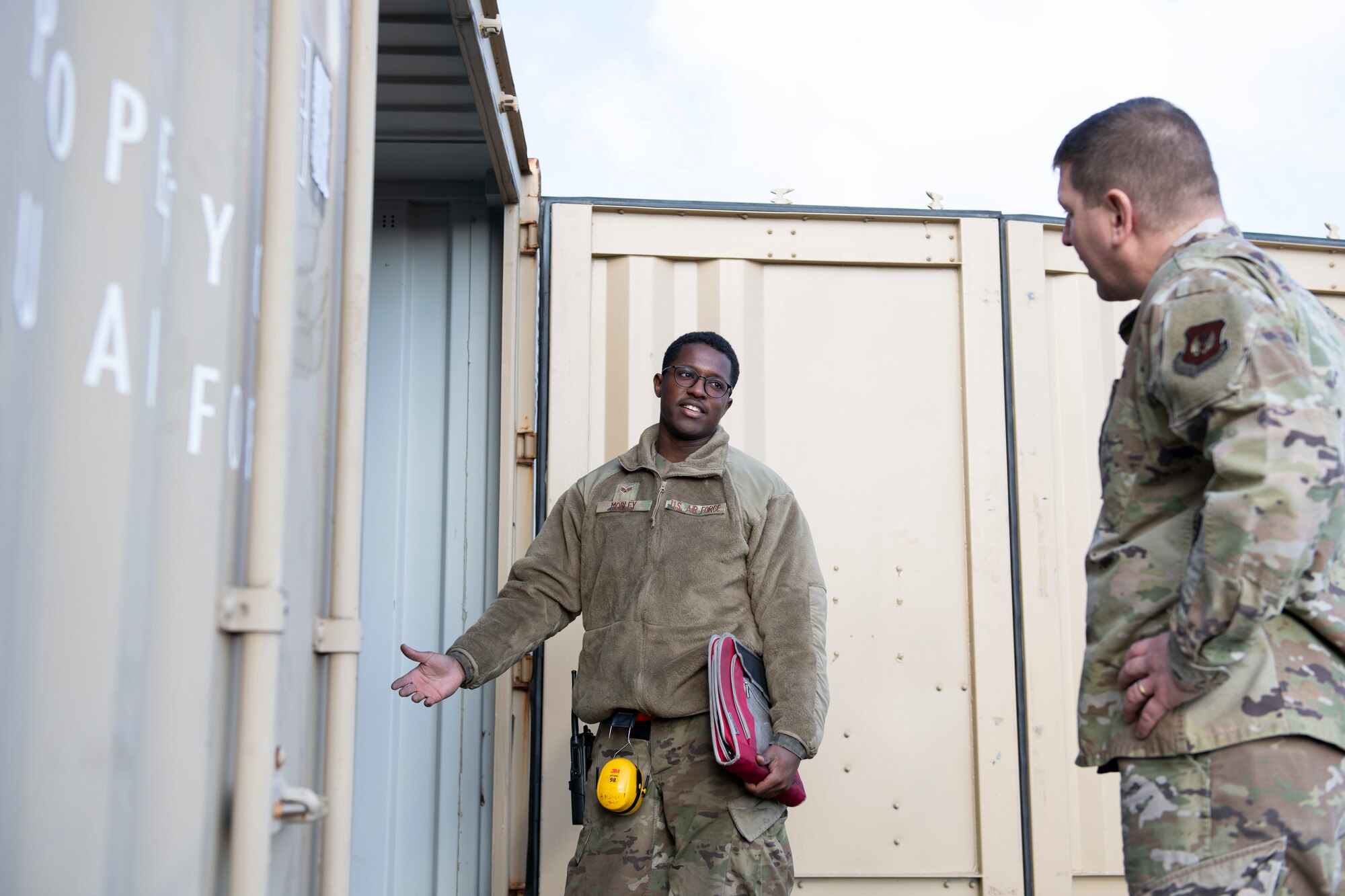 U.S. Air Force Senior Airman Andre Mobley, left, 420th Munitions Squadron stockpile technician, shares with Col. Kurt Wendt, right, 501st Combat Support Wing commander, information about the necessary cleaning and qualifications for explosive International Standards Organization (ISO) shipping containers, during a visit to RAF Welford, England, Oct. 1, 2020. Wendt visited 420th MUNS to meet with the Airmen and to learn more about their new mission capabilities. (U.S. Air Force photo by Senior Airman Jennifer Zima)