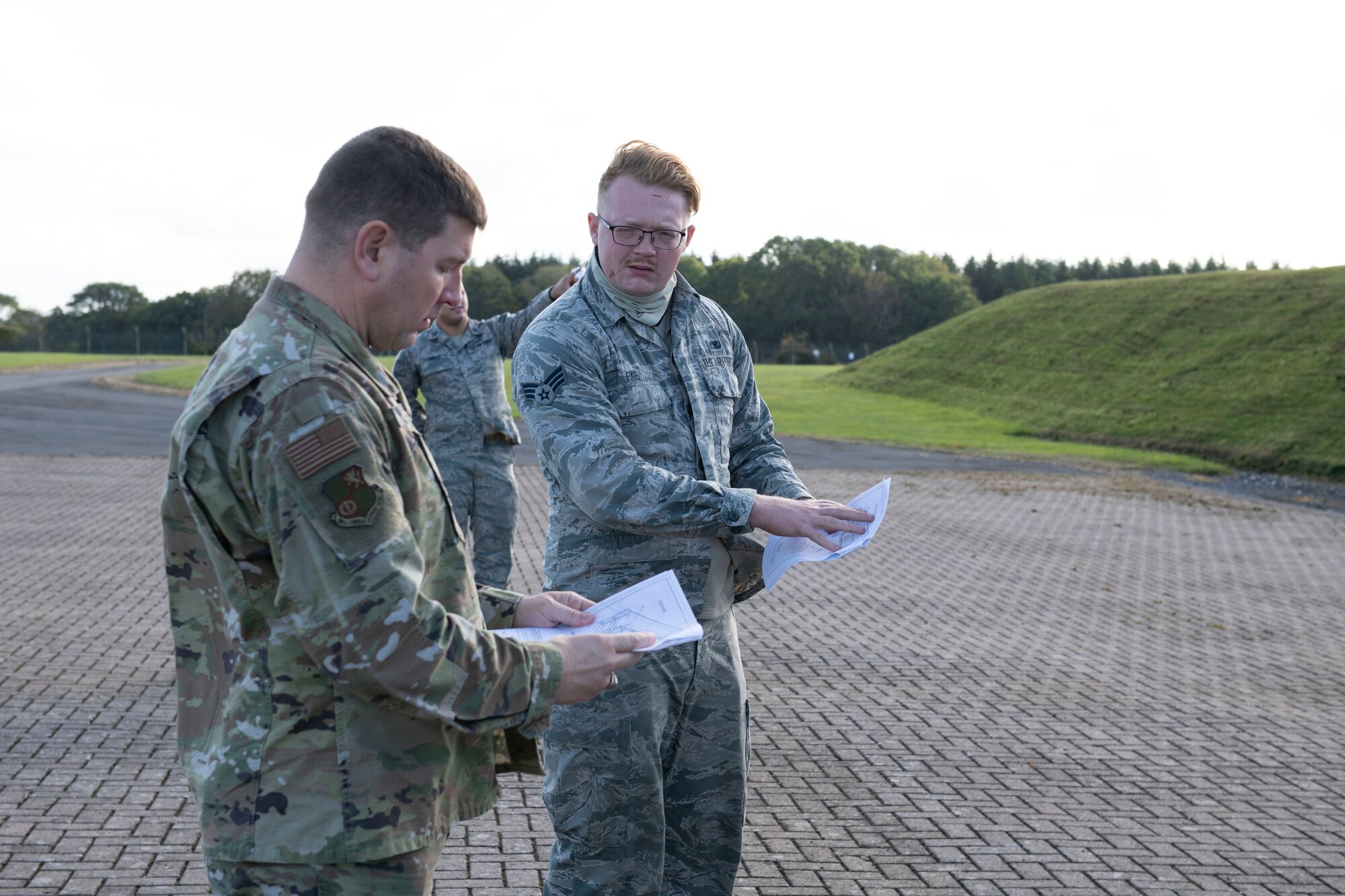 U.S. Air Force Senior Airman Ian Fike, right, 420th Munitions Squadron conventional maintenance crew chief, shows Col. Kurt Wendt, left, 501st Combat Support Wing commander, regulations and instructions to build wooden blocking and bracing to secure munitions during shipment, during a visit to RAF Welford, England, Oct. 1, 2020. Wendt visited 420th MUNS to meet with the Airmen and to learn more about their new mission capabilities. (U.S. Air Force photo by Senior Airman Jennifer Zima)