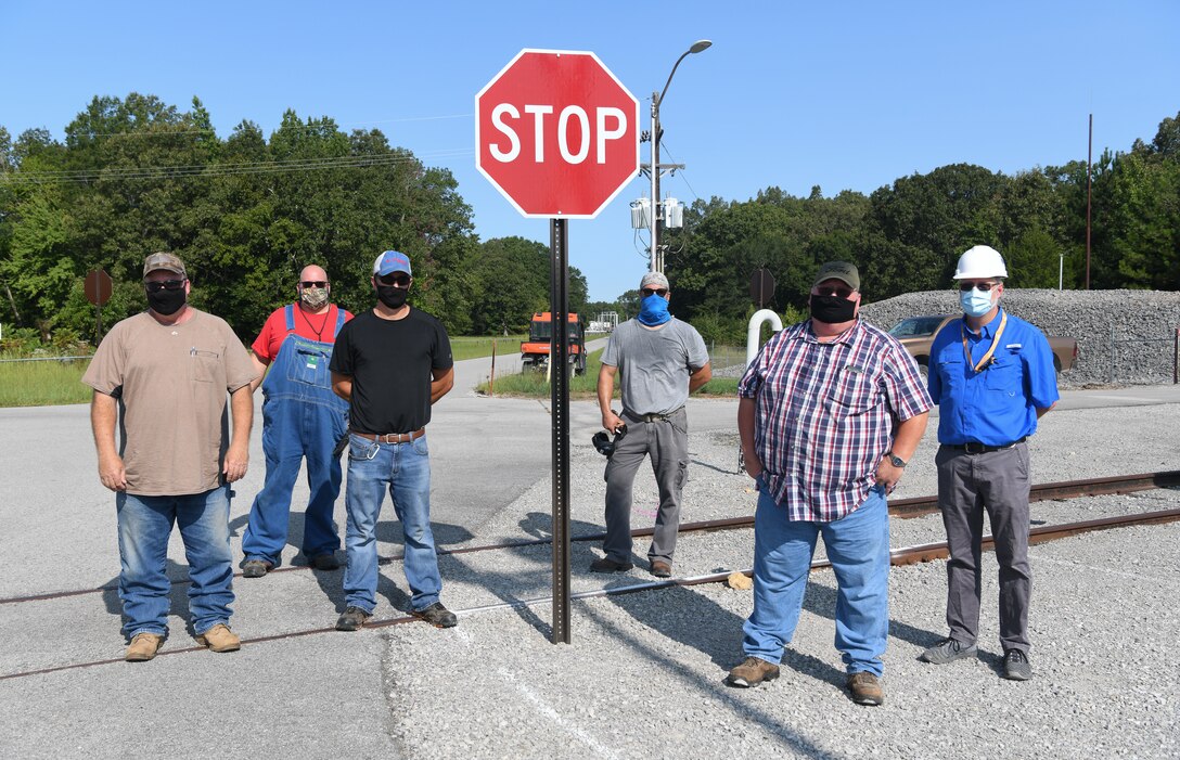 Newly-installed stop signs were uncovered at an intersection near the J-4 Rocket Motor Test Facility at Arnold Air Force Base, Tenn., Sept. 11, 2020, after the risk of a vehicle accident was raised by fuel farm machinist David Scheuermann, third from right. Also pictured are, from left, Tim Sullivan, Safety Leadership Committee chairman; Tony Buchanan, lead craftsman for the stop sign installation; Danny Smartt, laborer; Kelvin Sweeton, laborer; and Hunter Beavers, system engineer for roads and buildings. (U.S. Air Force photo by Jill Pickett)