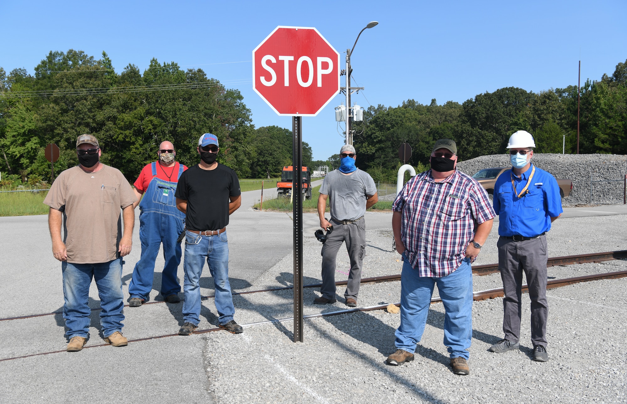 Newly-installed stop signs were uncovered at an intersection near the J-4 Rocket Motor Test Facility at Arnold Air Force Base, Tenn., Sept. 11, 2020, after the risk of a vehicle accident was raised by fuel farm machinist David Scheuermann, third from right. Also pictured are, from left, Tim Sullivan, Safety Leadership Committee chairman; Tony Buchanan, lead craftsman for the stop sign installation; Danny Smartt, laborer; Kelvin Sweeton, laborer; and Hunter Beavers, system engineer for roads and buildings. (U.S. Air Force photo by Jill Pickett)