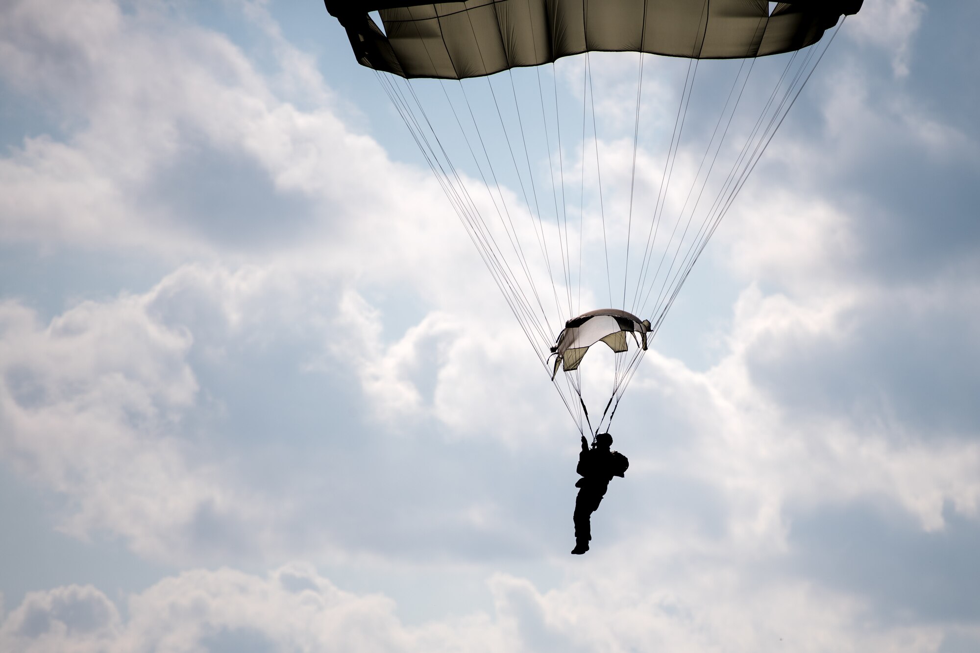 Photo of Airman descending with a parachute