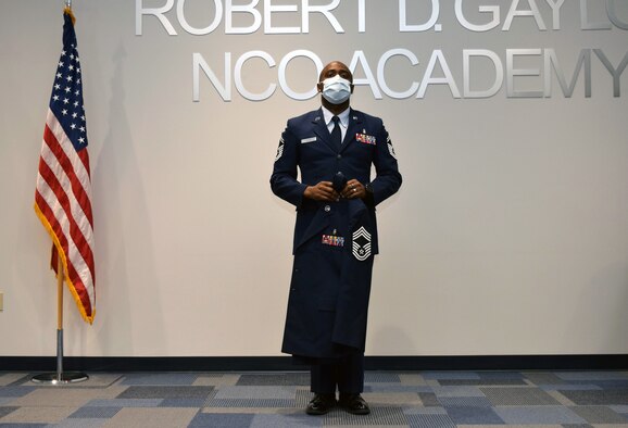 Howard Dixon, 433rd Medical Squadron, nurse services superintendent, holds a new uniform coat with the updated rank, while he waits for his family members to join him on stage at a ceremony celebrating his promotion to chief master sergeant, Oct. 3, 2020 at Joint Base San Antonio-Lackland, Texas.