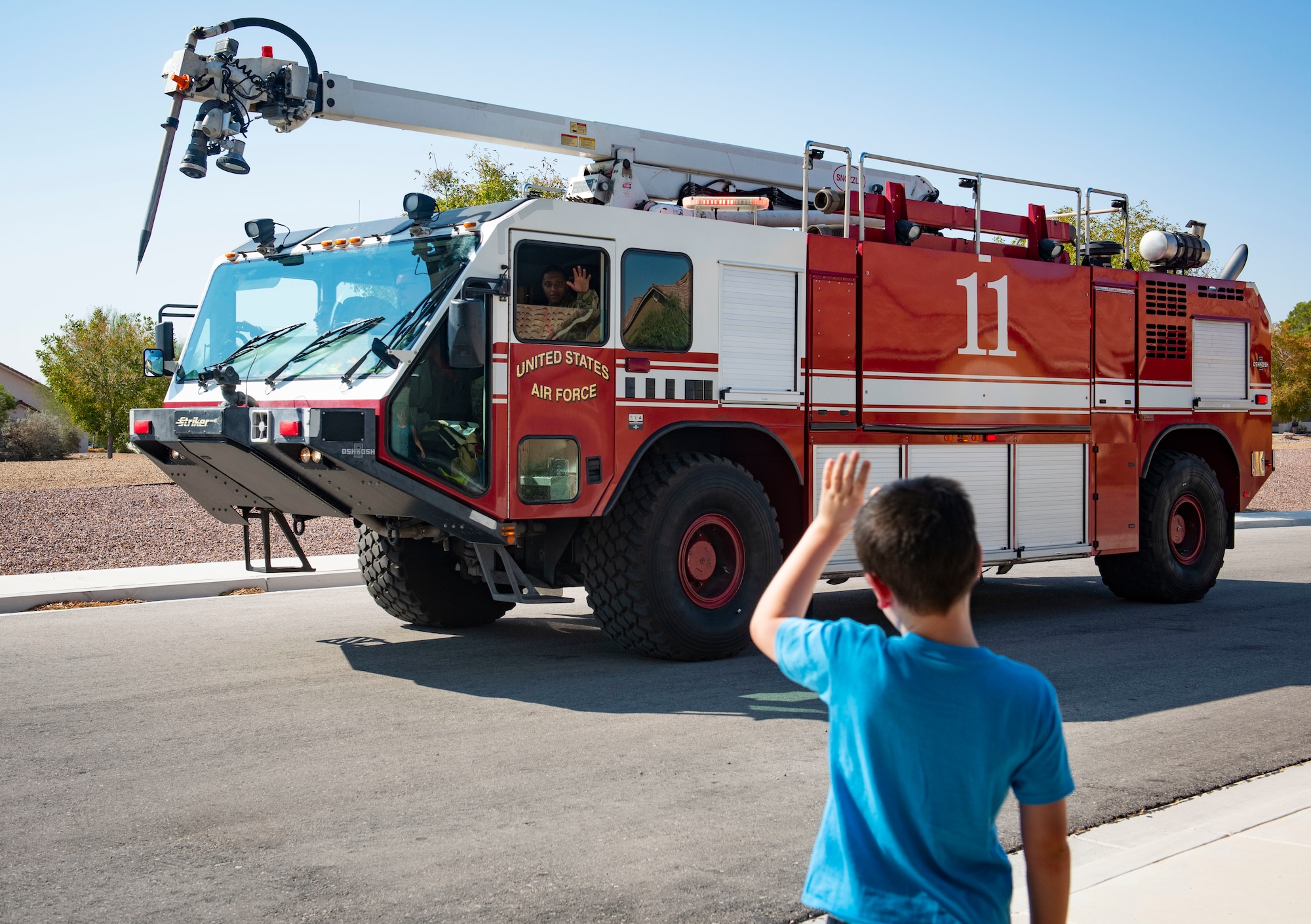 Child waves at firetruck.