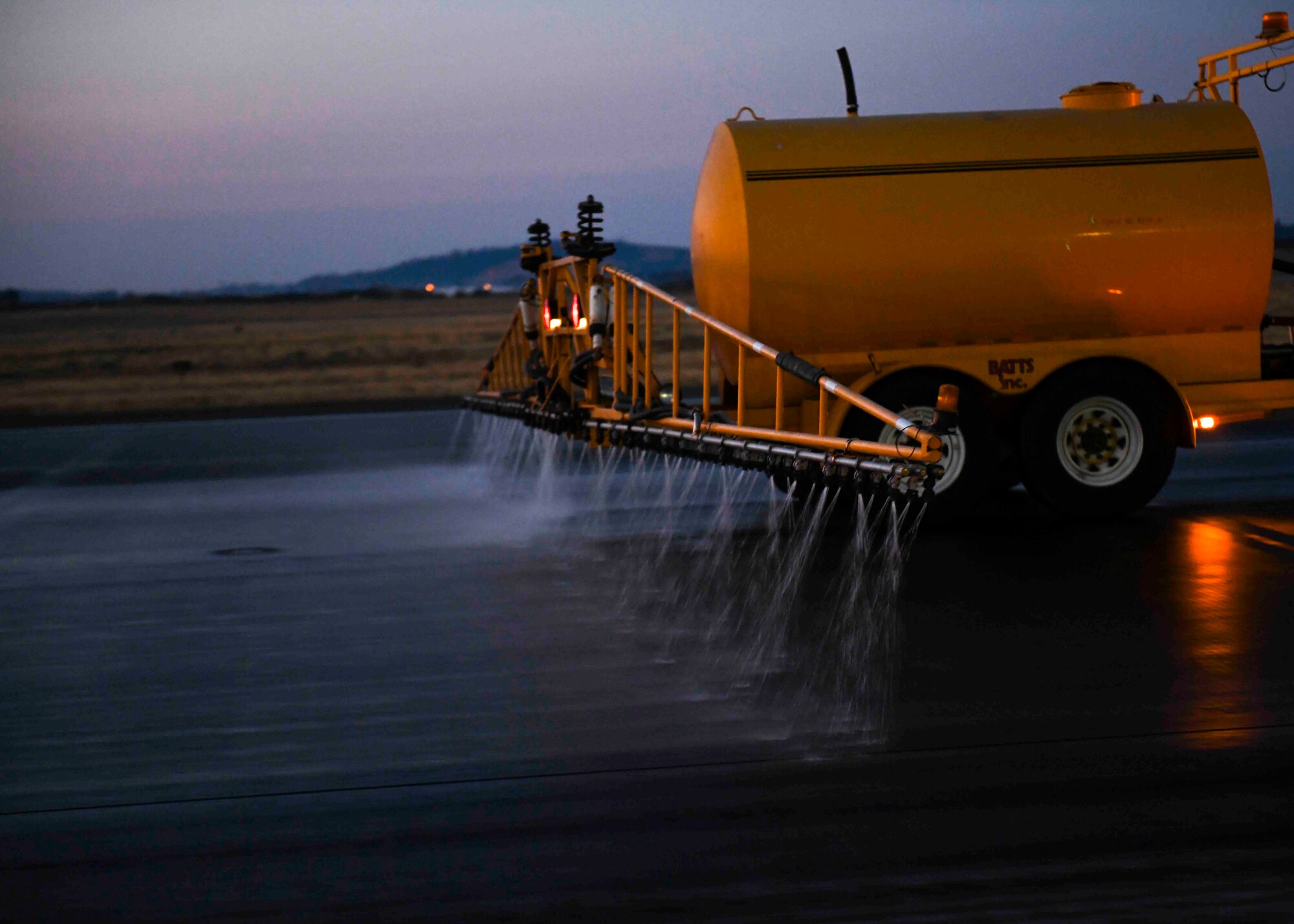 A 92nd Civil Engineering Squadron Airmen operates a de-icing vehicle, spraying water during flightline rubber removal at Fairchild Air Force Base, Washington, Oct. 3, 2020. Team Fairchild Airmen removed rubber from the flightline spanning over 30,000 miles. (U.S. Air Force photo by Airman 1st Class Kiaundra Miller)