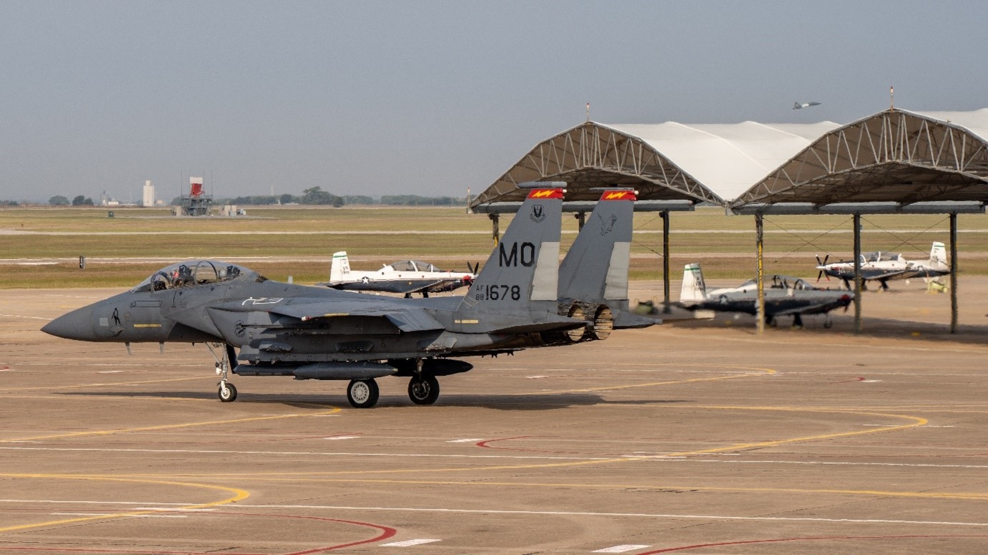 An F-15E Strike Eagle from the 389th Fighter Squadron taxis for takeoff at Vance AFB while student pilots start and taxi in the T-6 Texan II pilot trainer. (U.S. Air Force photo by Maj. Mark Calendine)