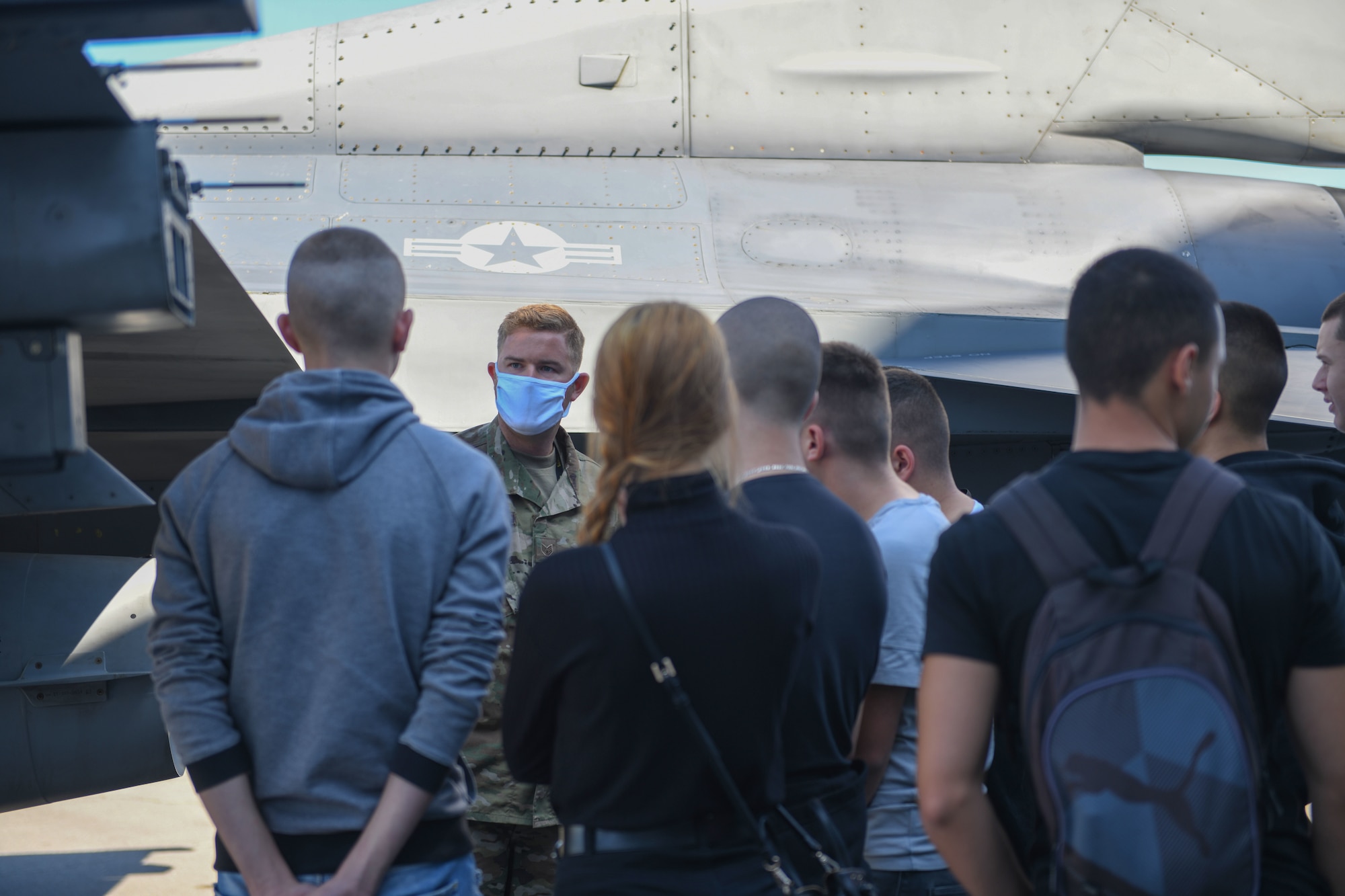 U.S. Air Force Staff Sgt. Richard Rygiel, 31st Aircraft Maintenance Squadron crew chief, speaks to students from First English Language School, Sofia, Bulgaria, during NATO enhanced Air Policing Oct. 2, 2020, at Graf Ignatievo Air Base, Bulgaria. The First English Language School was founded in 1958 as a high school for education in English language. During their visit, the students learned about various parts of a U.S. Air Force F-16 Fighting Falcon, and had the opportunity to sit in the cockpit of the aircraft. (U.S. Air Force photo by Airman 1st Class Ericka A. Woolever)