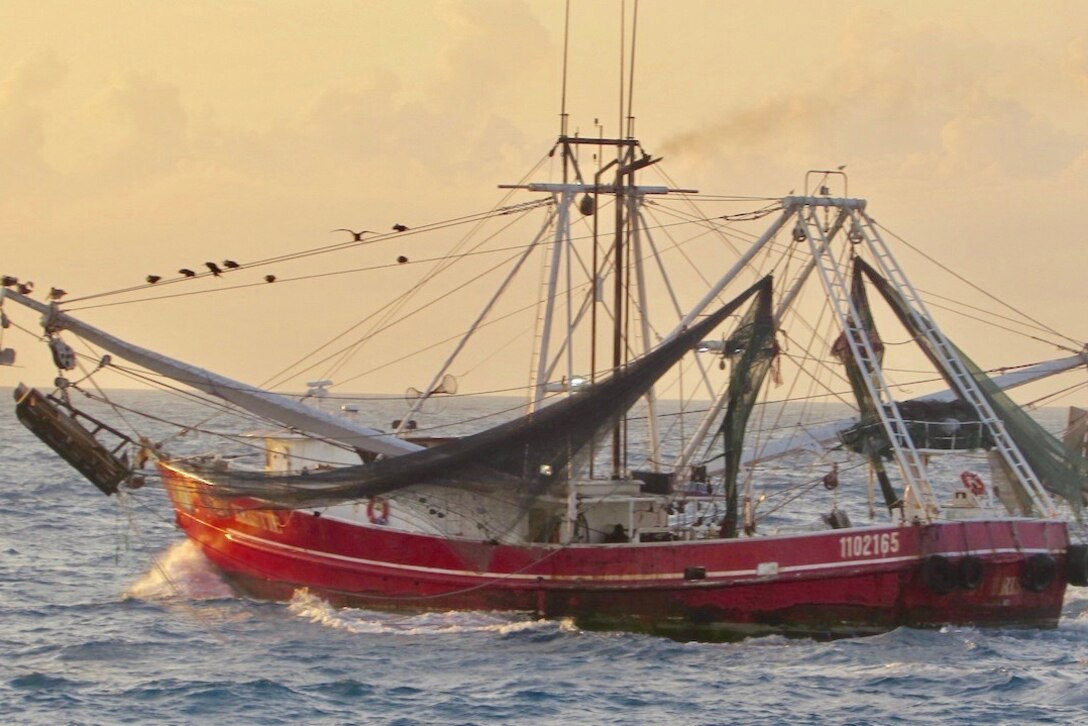 A fishing vessel is intercepted by a Coast Guard cutter.