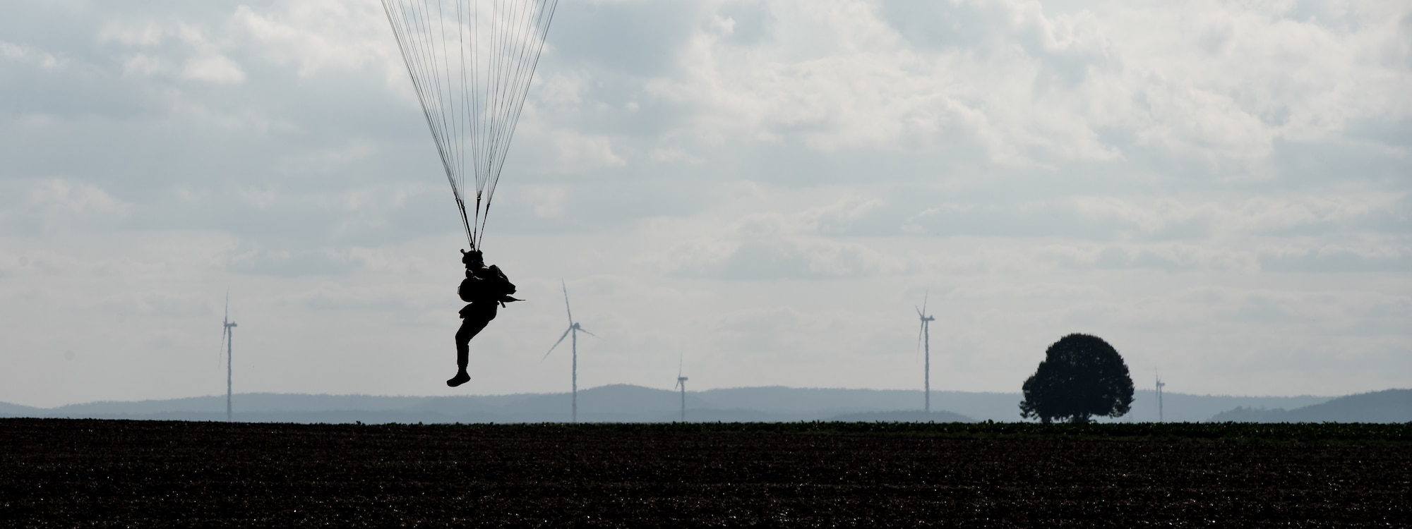 Photo of Airman descending with a parachute