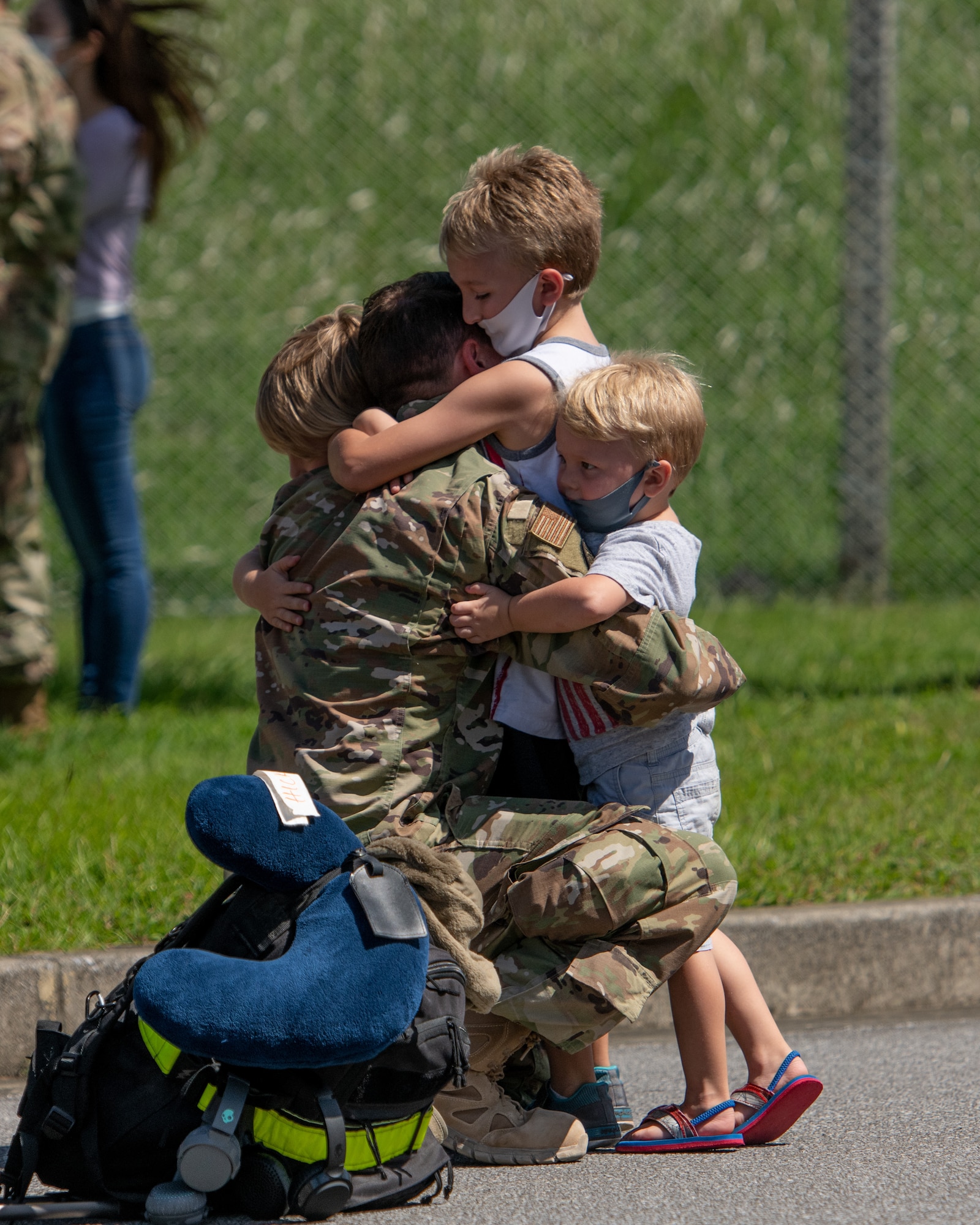 A U.S. Air Force Airman embraces his children upon returning from a deployment to U.S. Central Command Oct. 6, 2020, at Kadena Air Base, Japan. Airmen from the 18th Operations and Maintenance Groups deployed to the CENTCOM area of responsibility in support of ongoing operations to maintain air superiority, defend forces on the ground, enhance regional partnerships, and demonstrate a continued commitment to regional security and stability. (U.S. Air Force photo by Staff Sgt. Peter Reft)