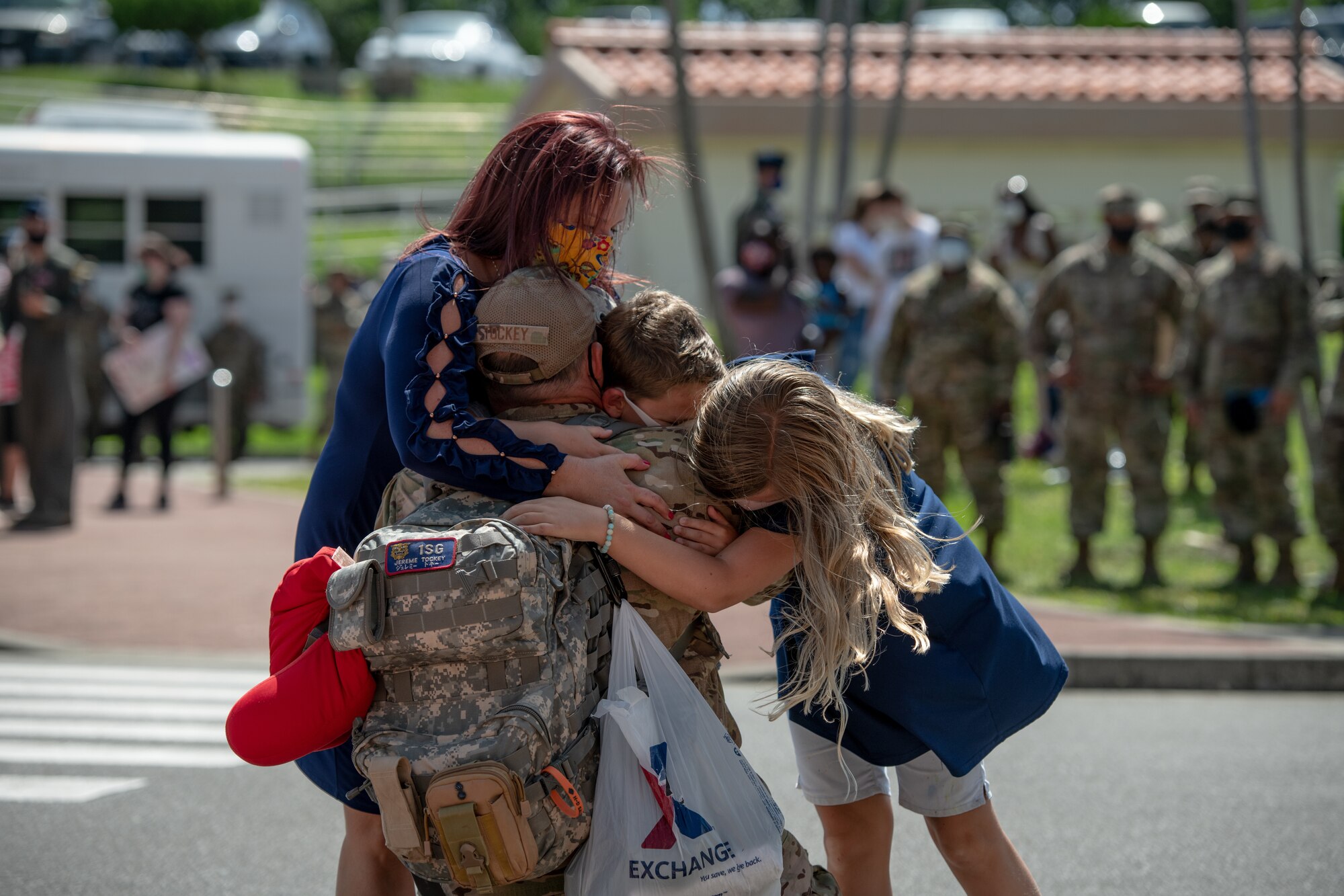 U.S. Air Force Master Sgt. Jereme Tockey, 18th Aircraft Maintenance Squadron first sergeant, embraces his family after returning from a deployment to U.S. Central Command Oct. 6, 2020, at Kadena Air Base, Japan. While deployed to the CENTCOM area of responsibility, Airmen conducted more than 1,000 sorties and 5,300 combat hours, which drove 13 phase inspections in six months. They’ll share the skills they learned in combat with Team Kadena, joint partners and allies to ensure a free and open Indo-Pacific. (U.S. Air Force photo by Staff Sgt. Peter Reft)