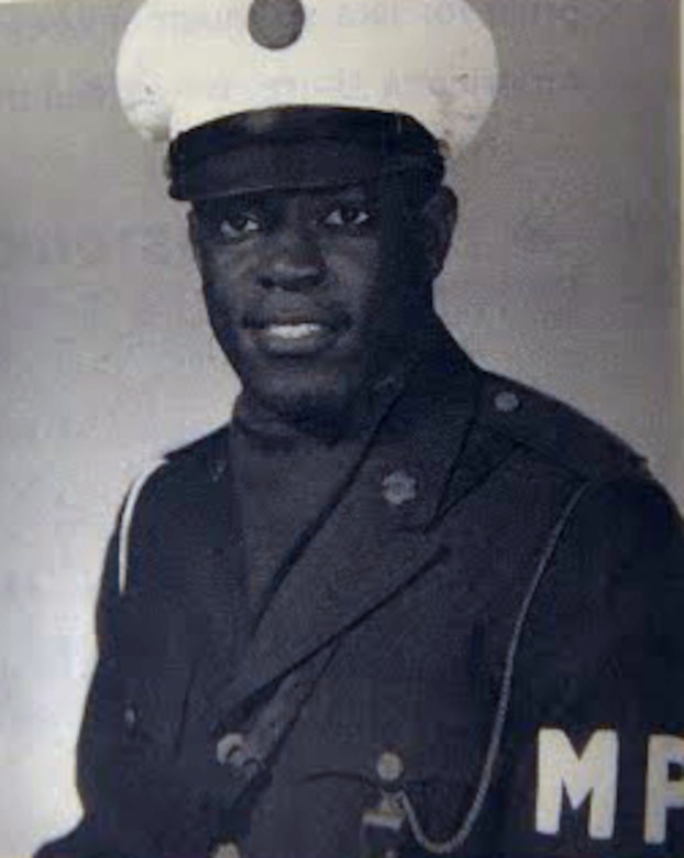 A man in a military police uniform poses for a head shot.