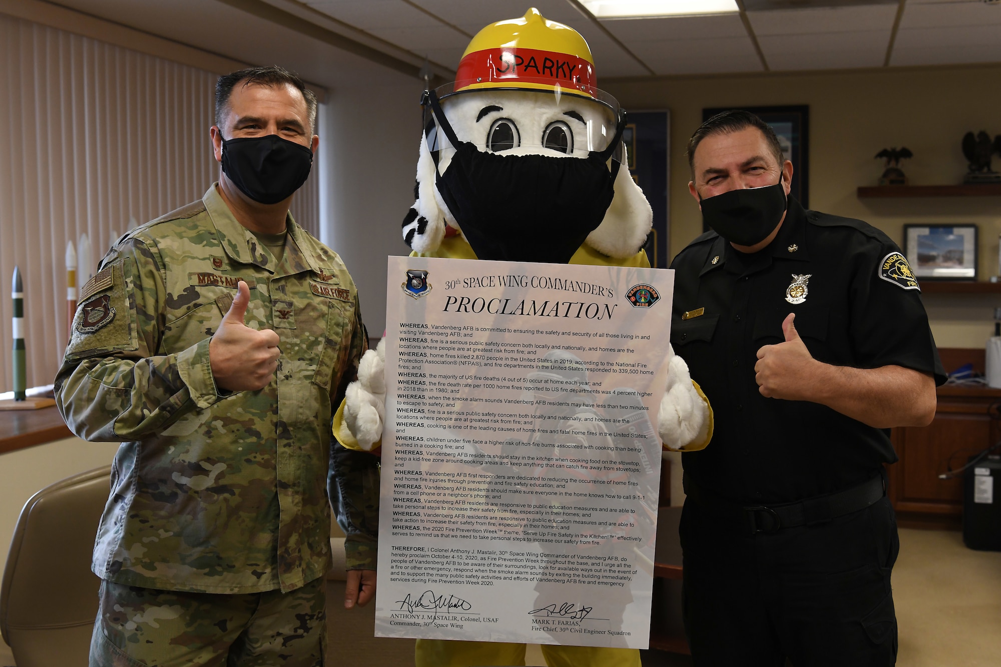 Col. Anthony Mastalir, 30th Space Wing commander, and Mark Farias, 30th Civil Engineer Squadron fire chief, and Sparky the Fire Dog pose with the signed 2020 Fire Proclamation Oct. 5, 2020, at Vandenberg Air Force Base, Calif.
