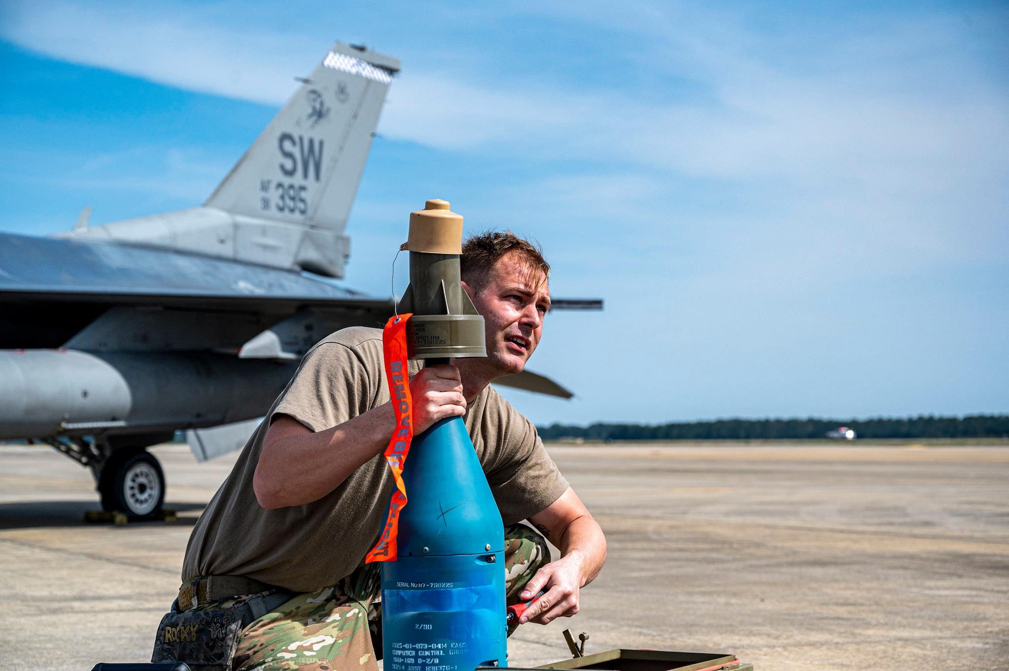 An Airman holds a munition on the flightline.