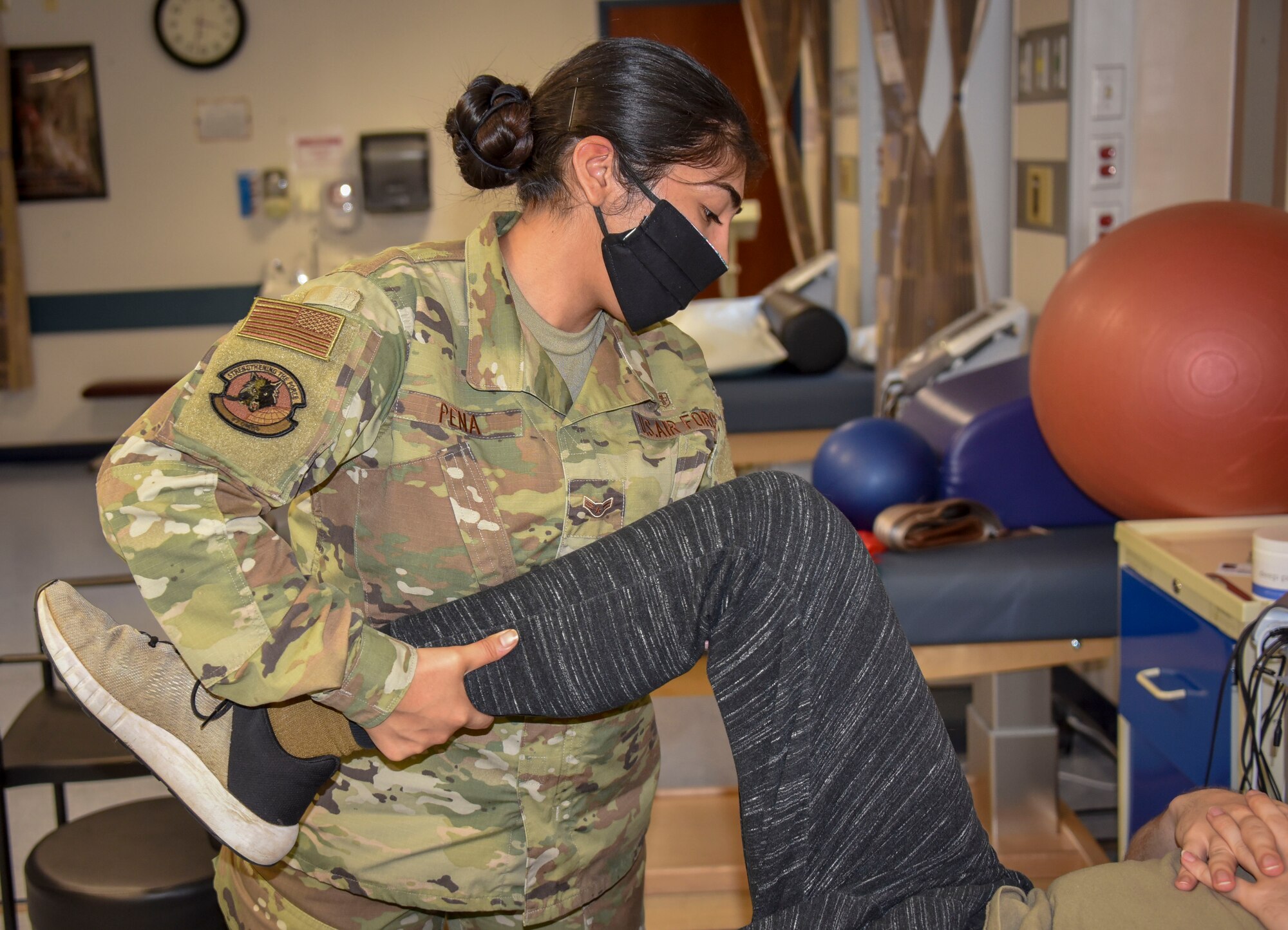 Photo of an Airman working with a patients leg.