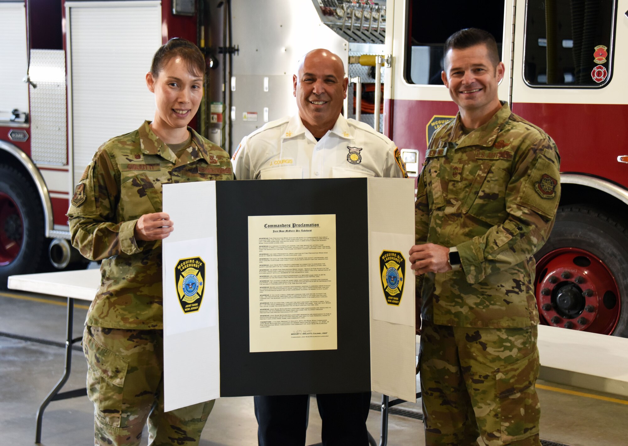 A photo of three individuals holding a Fire Prevention Week proclamation.