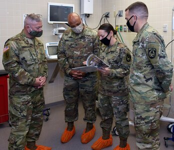 Maj. Laura Riddle (center), chief of veterinary support branch at the U.S. Army Institute of Surgical Research, describes how research spaces were transformed into an intensive care unit to support a possible overflow of COVID-positive patients at Brooke Army Medical Center to Brig. Gen. Shan K. Bagby, BAMC commanding general, and BAMC Command Sgt. Maj. Thurman Reynolds.