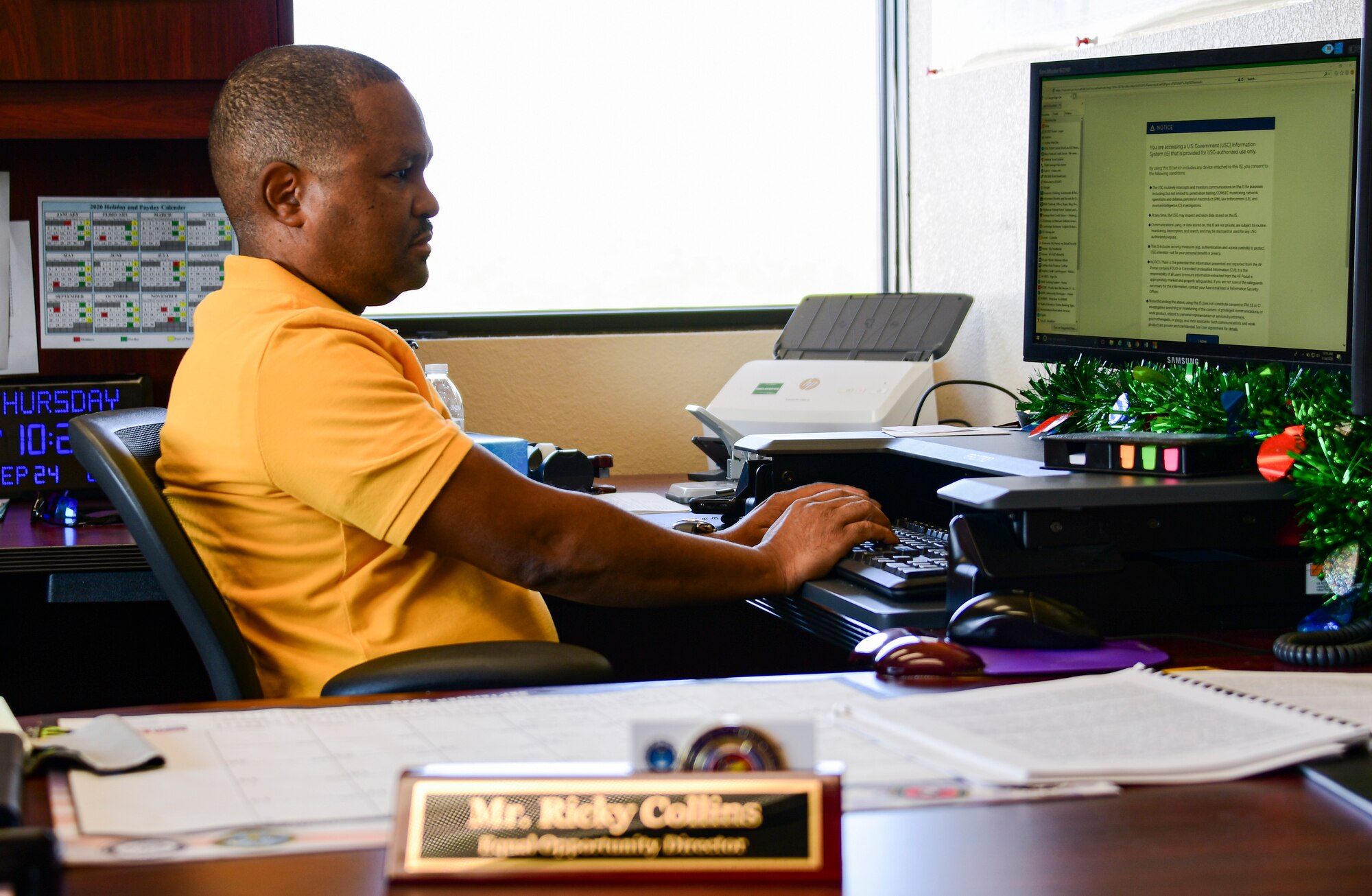 A photo of the EO director entering in information on the computer.