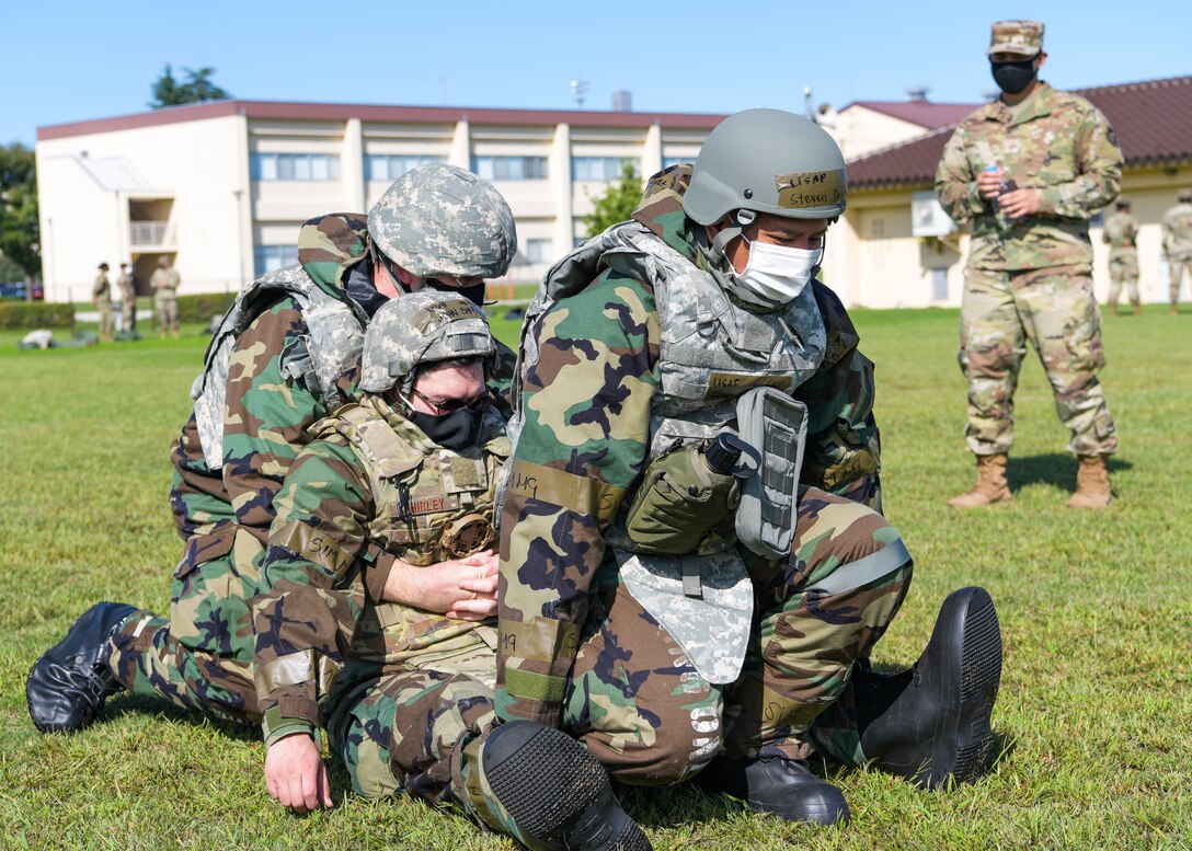 Airmen of the 374th Force Support Squadron practice buddy lifting procedures during the squadron's training day.