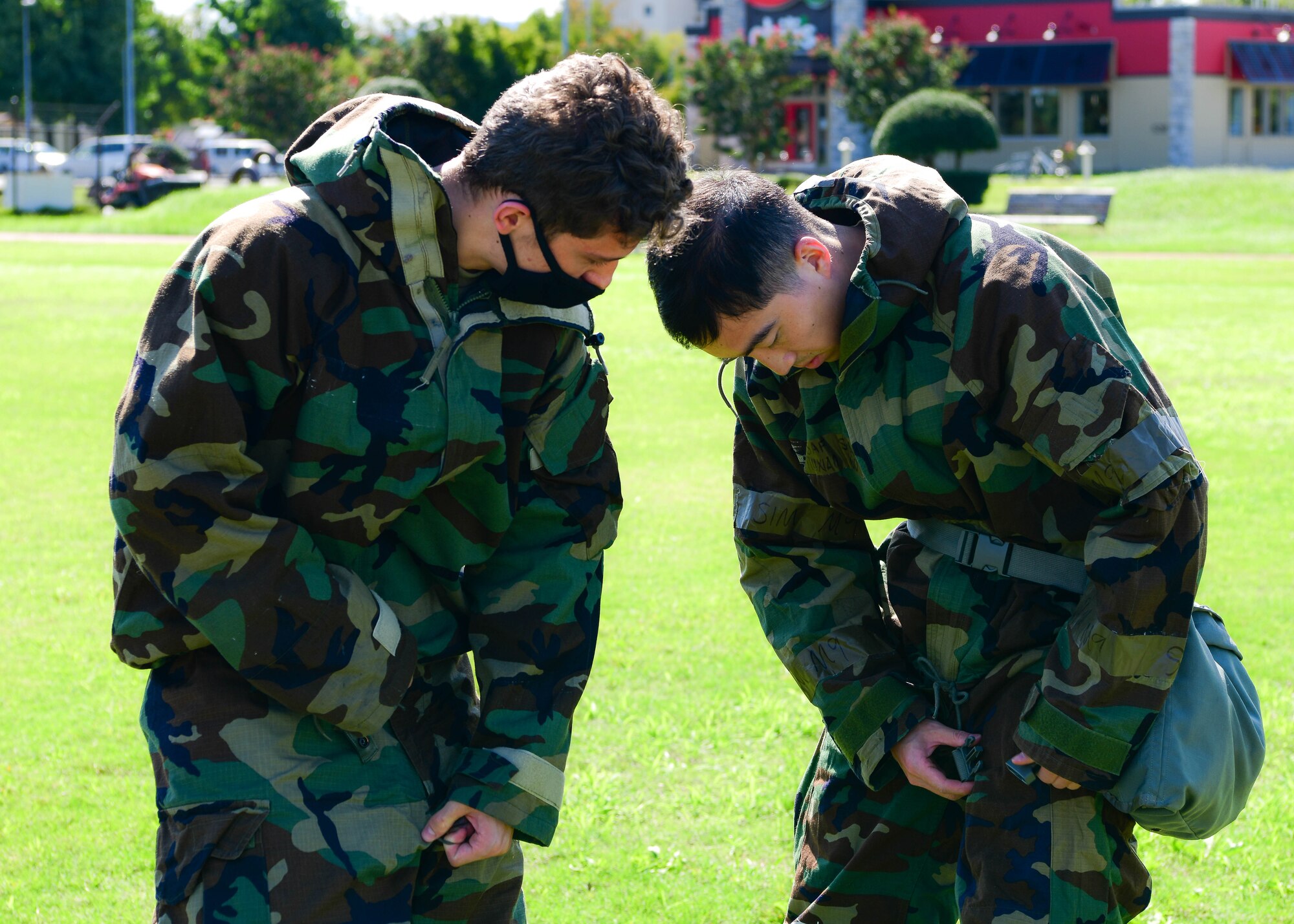 Airman 1st Class Adam Vittiello, 374th Force Support Squadron food services journeyman, left, ensures his wingman, Senior Airman Yinxiao Wu, 374th FSS fitness journeyman, dons his Mission Oriented Protective Posture gear accurately during the squadron's war fighting training day.