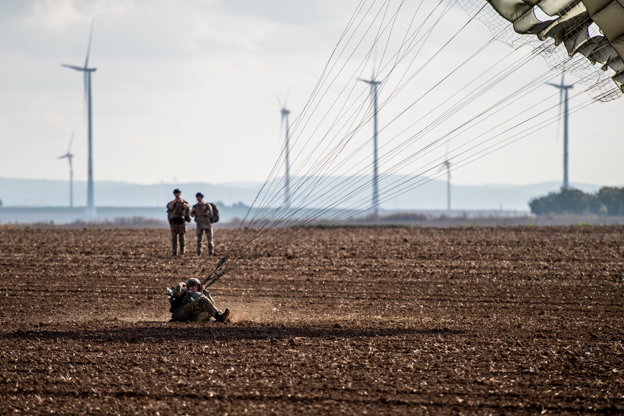 Photo of Airman landing with a parachute