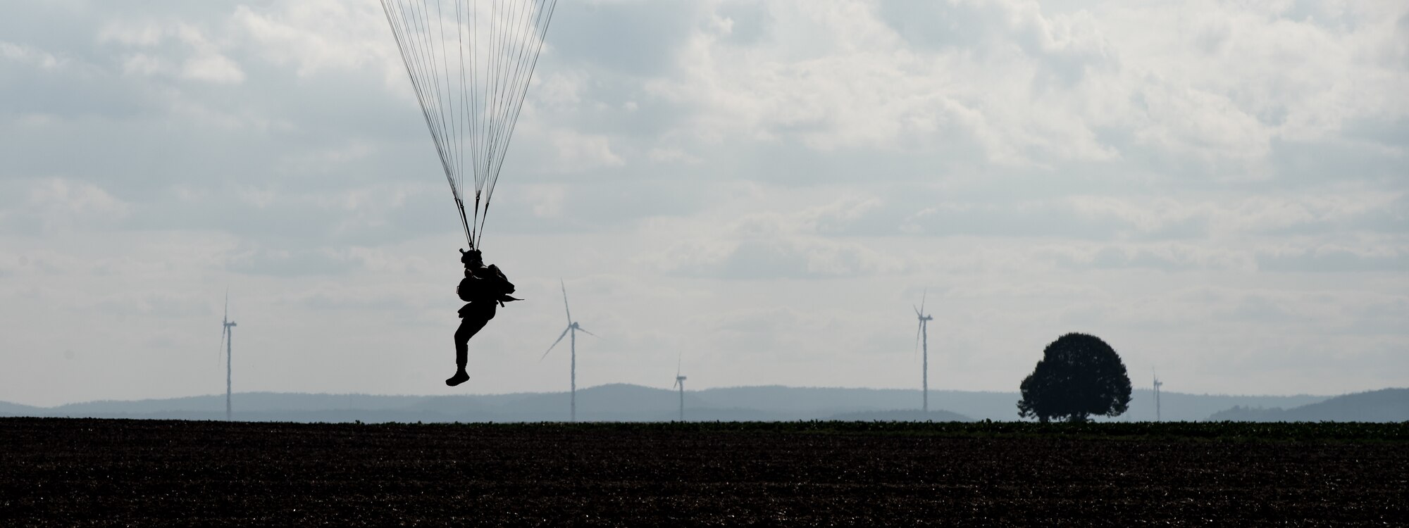 Photo of Airman descending with a parachute