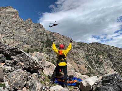 A Colorado Army National Guard UH-60 Black Hawk helicopter from the Army Aviation Support Facility, Buckley Air Force Base, Aurora, Colorado, approaches a member of the Alpine Rescue Team and an injured climber in Rocky Mountain National Park Aug. 30, 2019. The Colorado Hoist Rescue Team provides hoist extraction capability throughout Colorado by incorporating civilian alpine rescue personnel and military helicopter capabilities.