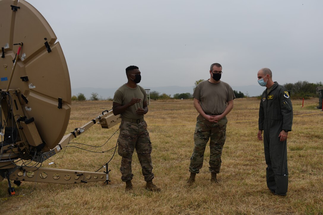 U.S. Air Force Brig. Gen. Jason Bailey, 31st Fighter Wing commander, right, speaks with U.S. Air Force Master Sgt. Jason Agnew, 1st Combat Communications Squadron sections of tactical cyber transport systems, center,  and Senior Airman Brendon Parks, 1st CBCS radio frequency technician, left, during NATO’s enhanced Air Policing Allied mission, at Graf Ignatievo Air Base, Bulgaria, Oct. 5, 2020. One of NATO’s roles is to preserve the integrity of allied airspace. Enhanced Air Policing is part of the alliance’s assurance measures for eastern allies. (U.S. Air Force photo by Airman 1st Class Ericka A. Woolever)