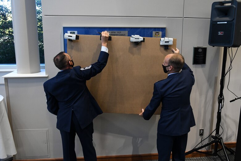 Chief Master Sgt. Christopher Williams, command chief of the 910th Airlift Wing, and Col. Joe Janik, commander of the 910th Airlift Wing, reveal a commemorative collage recognizing the 2019 First Sergeant Council.