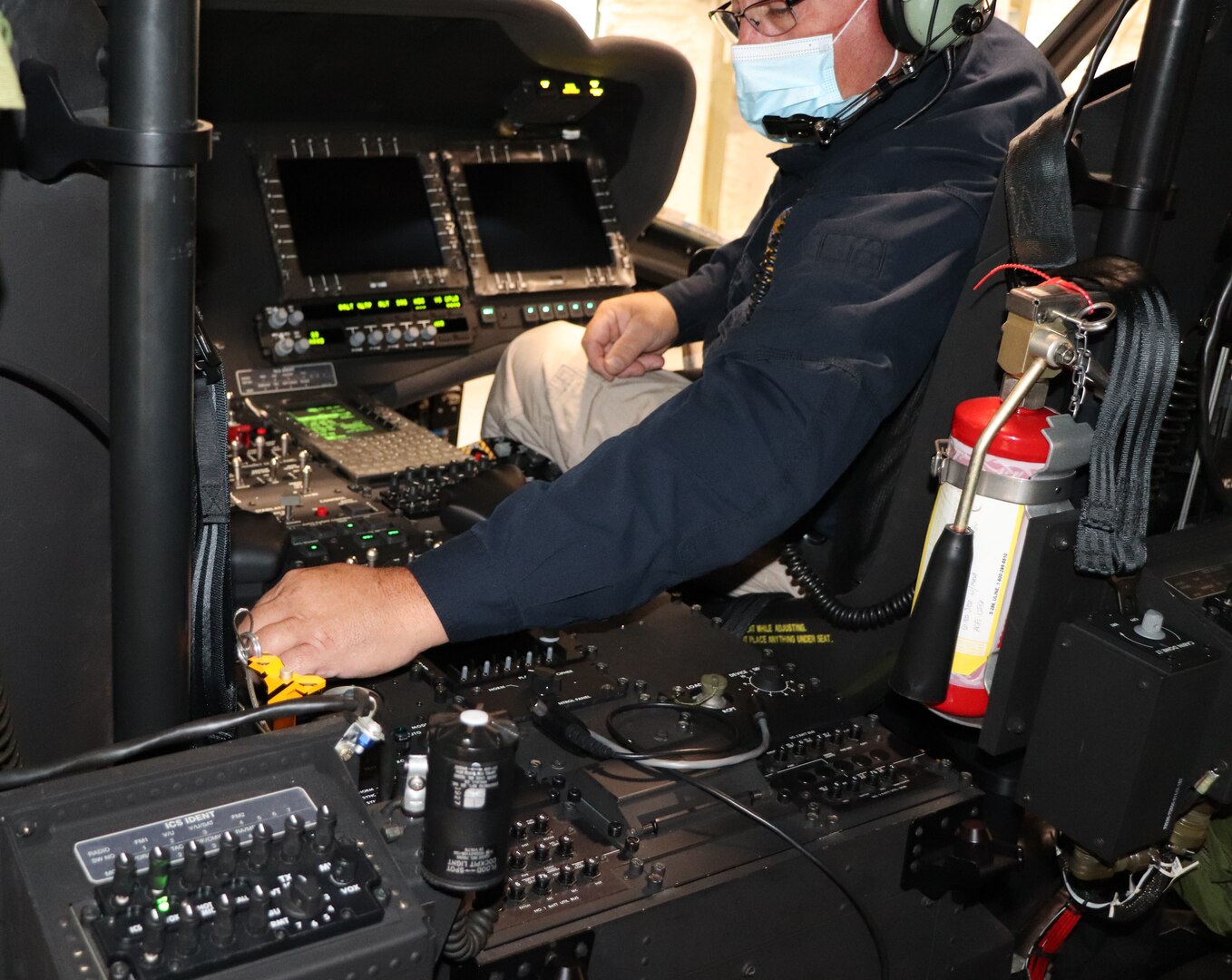 Lawrence Mitchell, a radio engineer from the New York State Office of Office of Interoperable and Emergency Communications, verifies the operation of a UH-60 radio by using the aircraft headset to conduct a radio test with another engineer on a portable radio at the Army Aviation Support Facility in Latham, New York, Sept. 30, 2020. Teams from the office uploaded civilian emergency response channels onto radios on all New York National Guard helicopters.